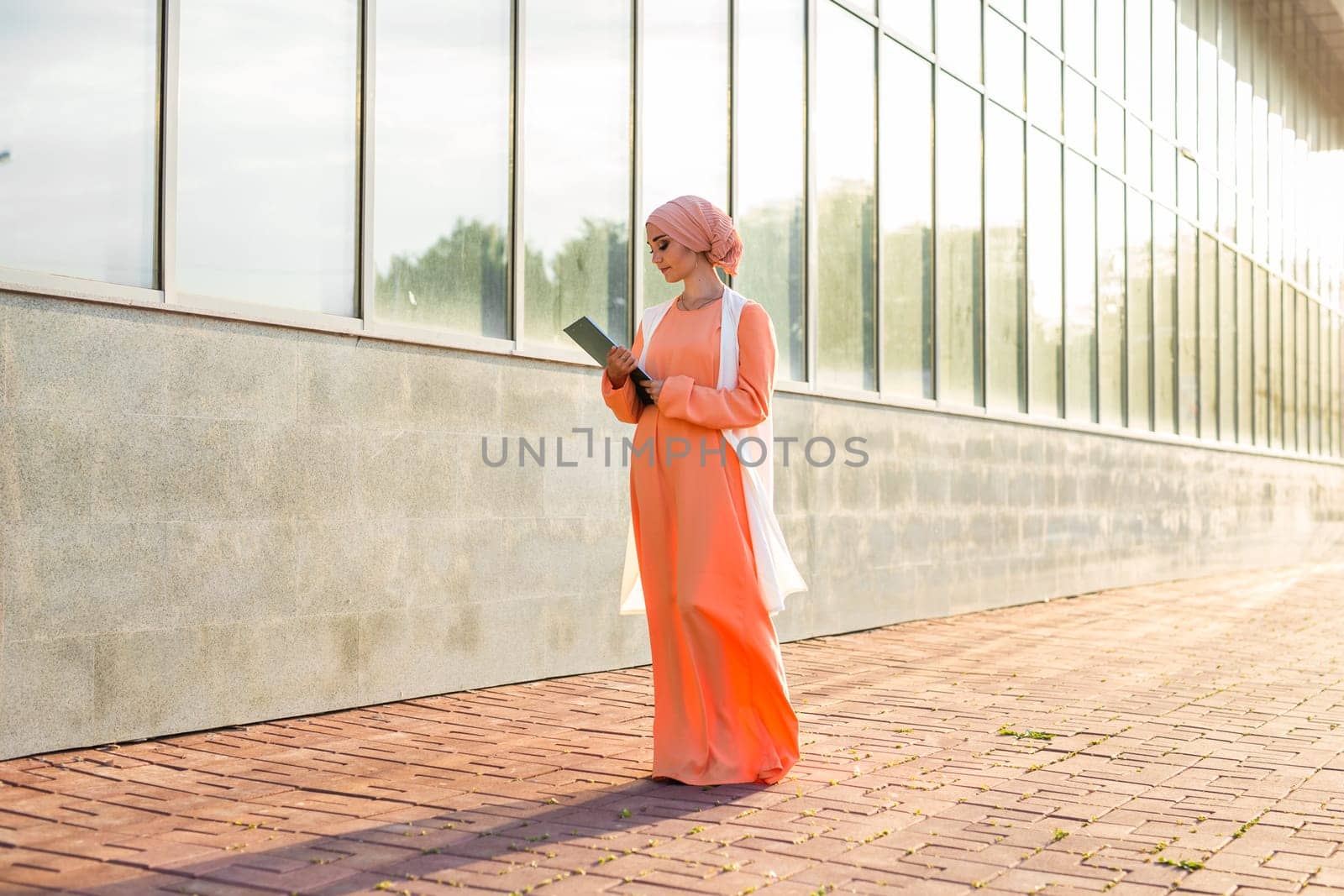 Young Muslim woman standing , holding document paper