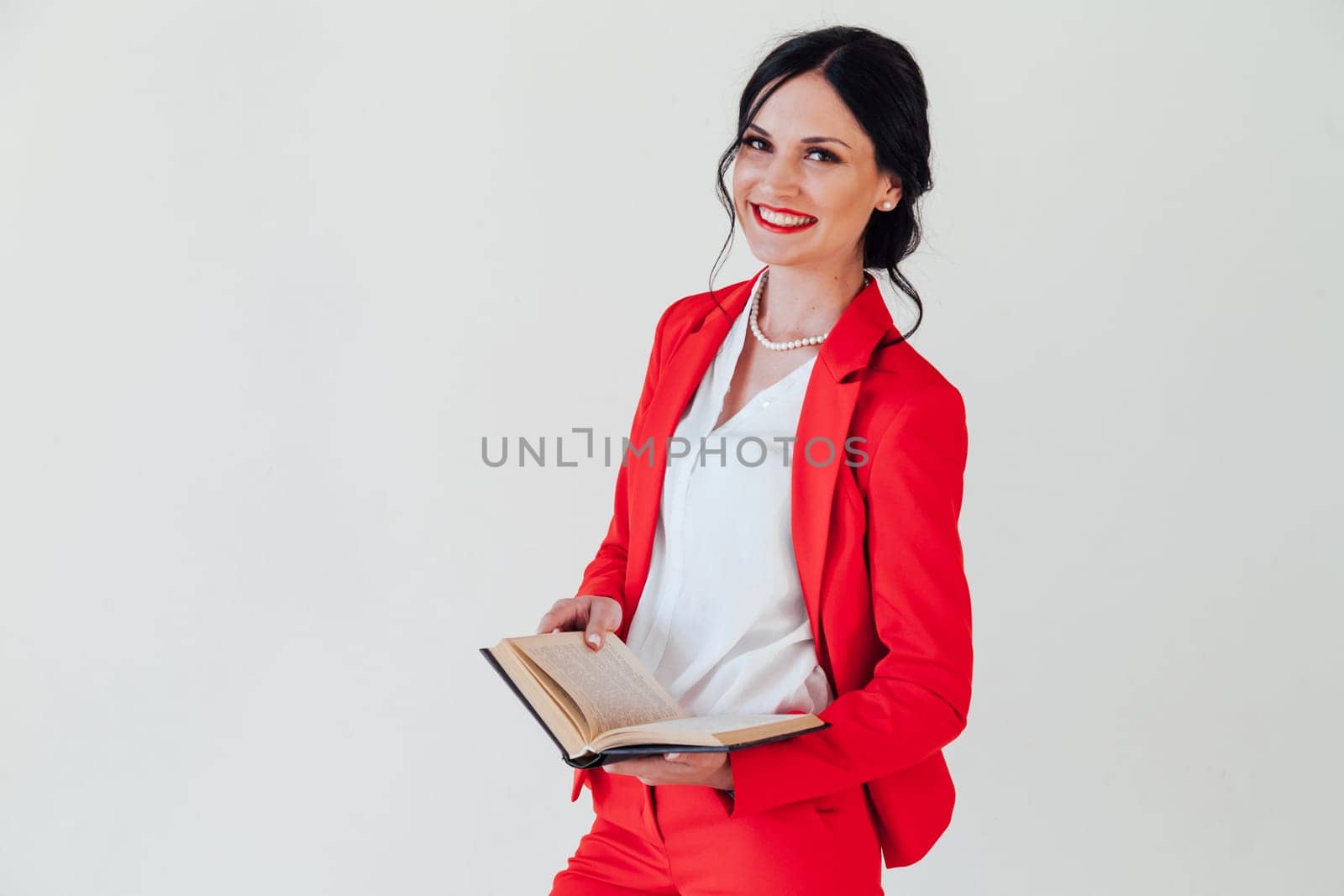 Beautiful female student in red business suit with book in hand by Simakov