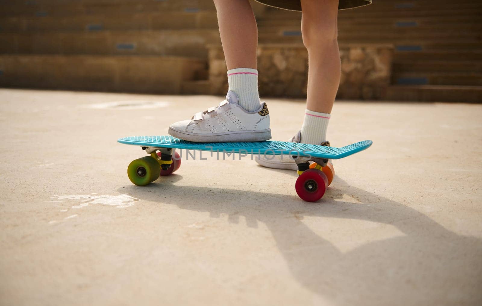 Skateboarding legs. Close-up child legs on a skateboard. by artgf