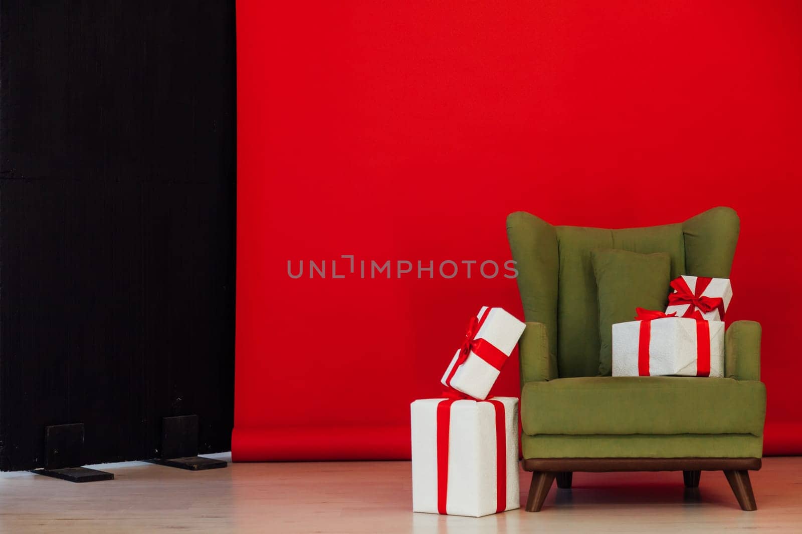 Red black background green chair with gifts for Christmas birthday party