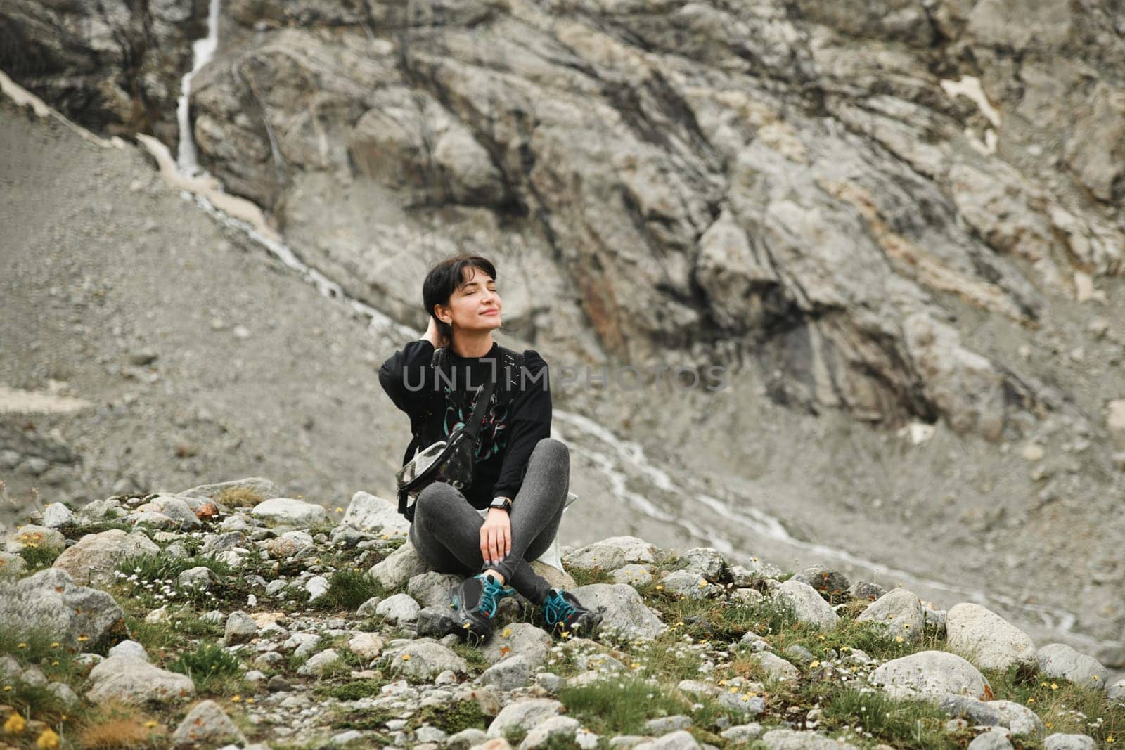 A woman meditating in the mountains by Godi