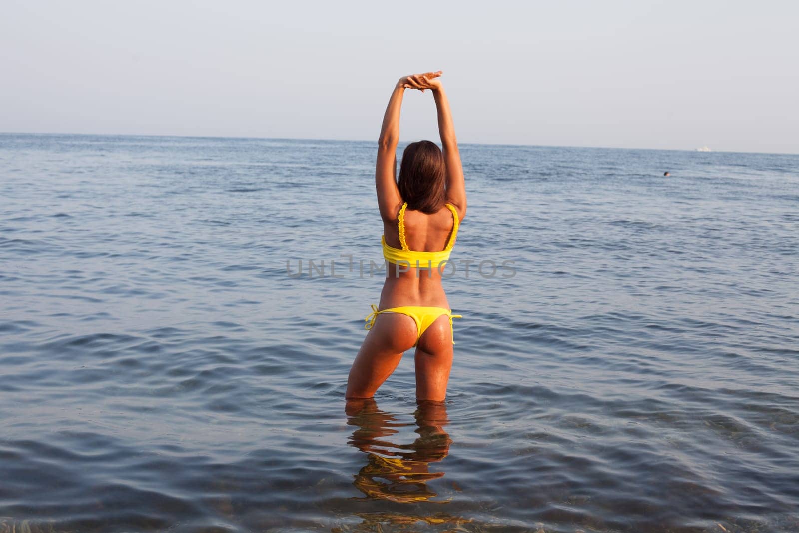 woman with long in yellow swimsuit on the beach