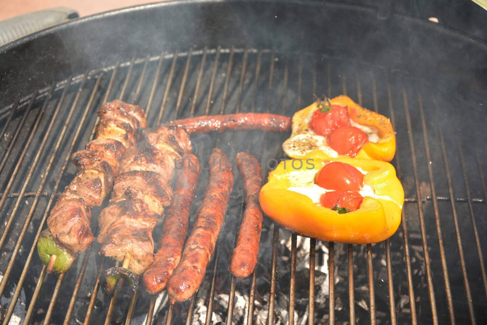 Delicious french sausages and meat on the barbecue grill