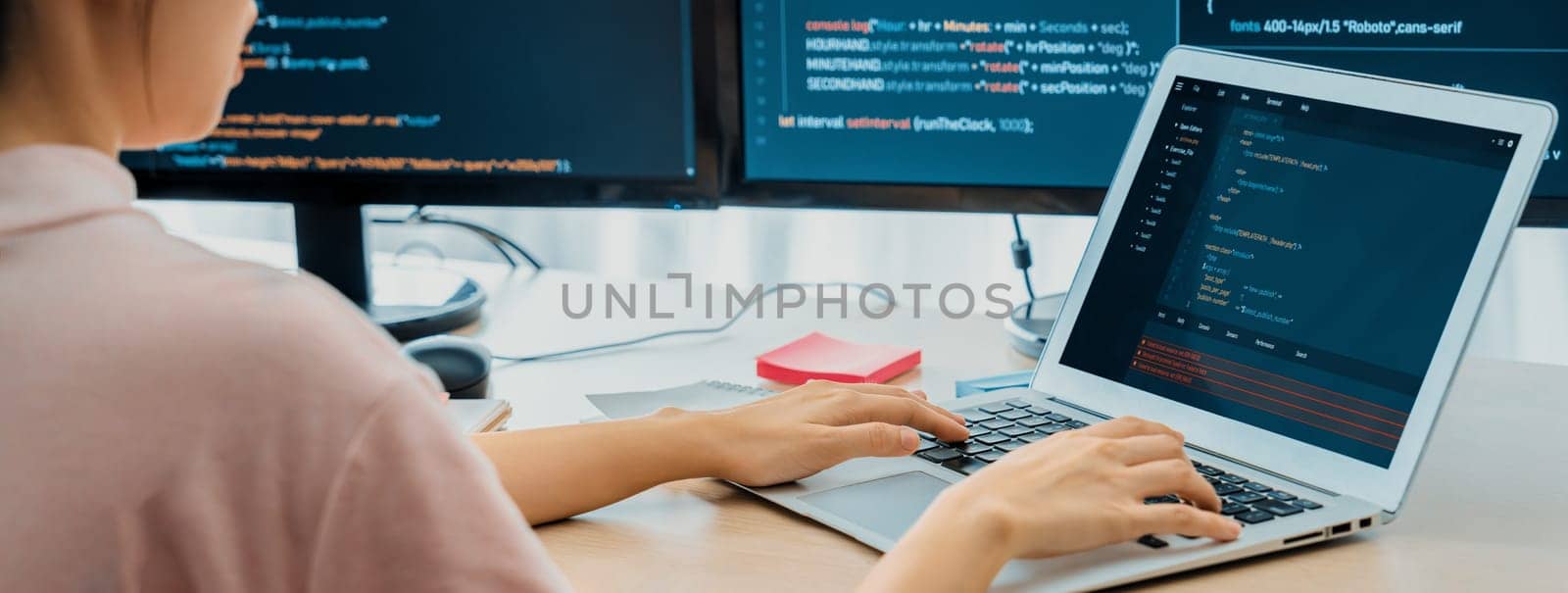 Cropped image of female web developer coding on laptop while computer displayed program and software code at modern office. Close up businesswoman hand focus on analysis data. Burgeoning.