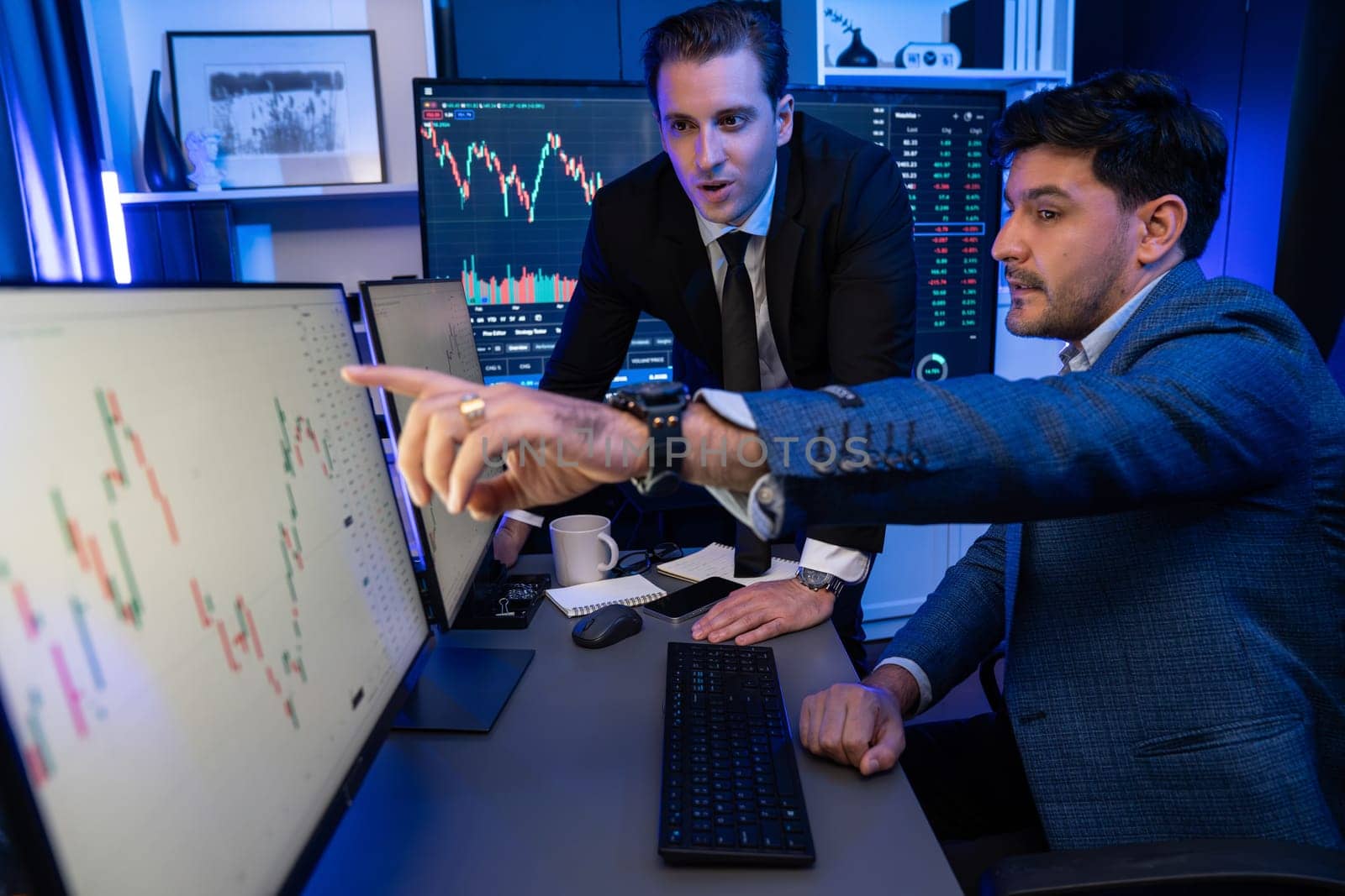 Stock exchange traders looking on high profit chart investment in panorama view, analyzing on monitor at night. Concept of discussing financial technology growth in neon light at workplace. Sellable.