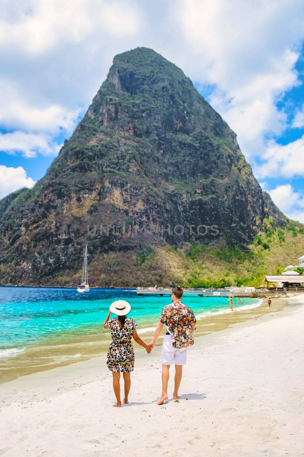 Young couple men and women on vacation in Saint Lucia, Asian women and Caucasian men on vacation at the tropical Island of Saint Lucia Caribbean at Sugar beach