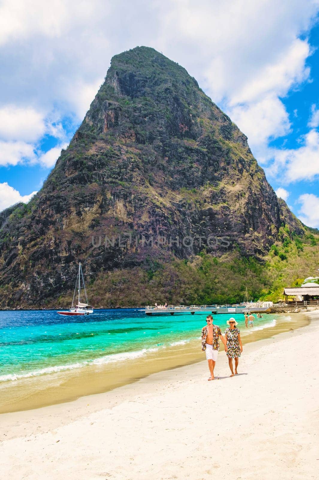 Young couple men and women on vacation in Saint Lucia, luxury holiday Saint Lucia Caribbean, diverse couple walking at Sugar Beach