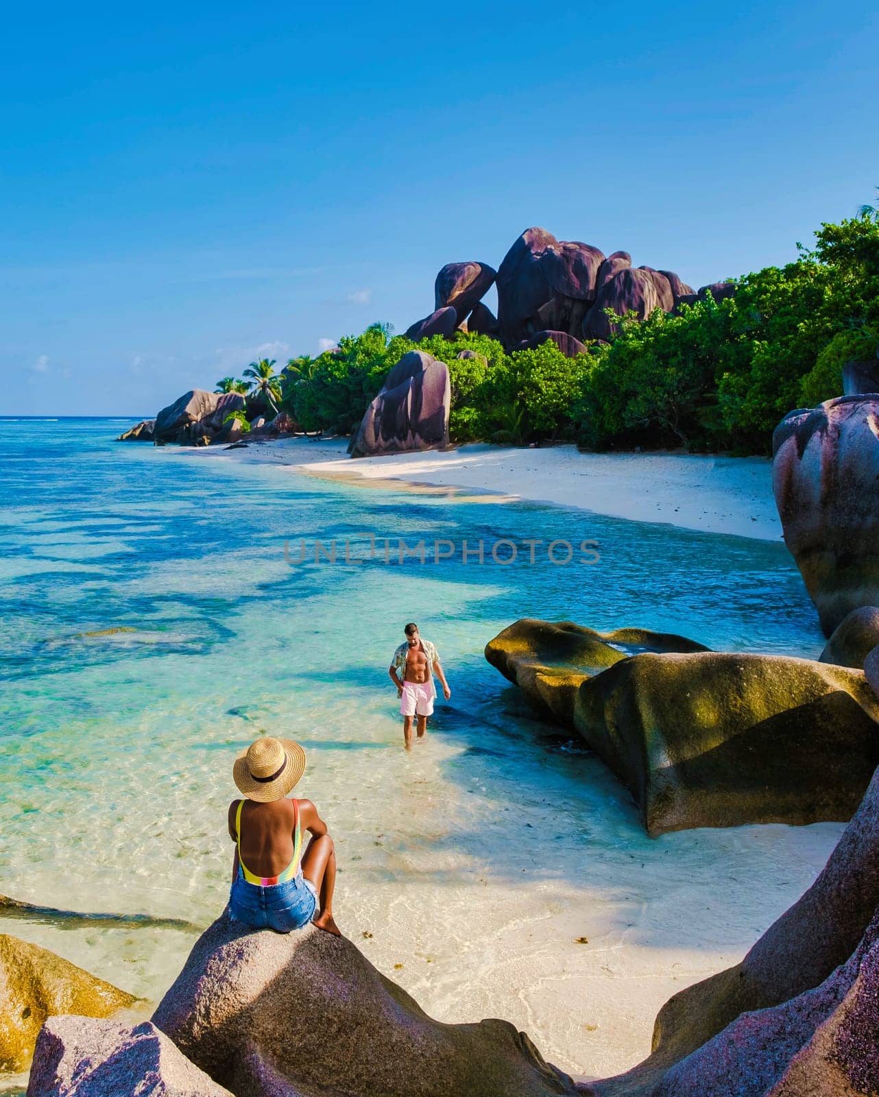 Anse Source d'Argent, La Digue Seychelles, a young couple of Caucasian men and Asian women on a tropical beach during a luxury vacation in La Digue Seychelles