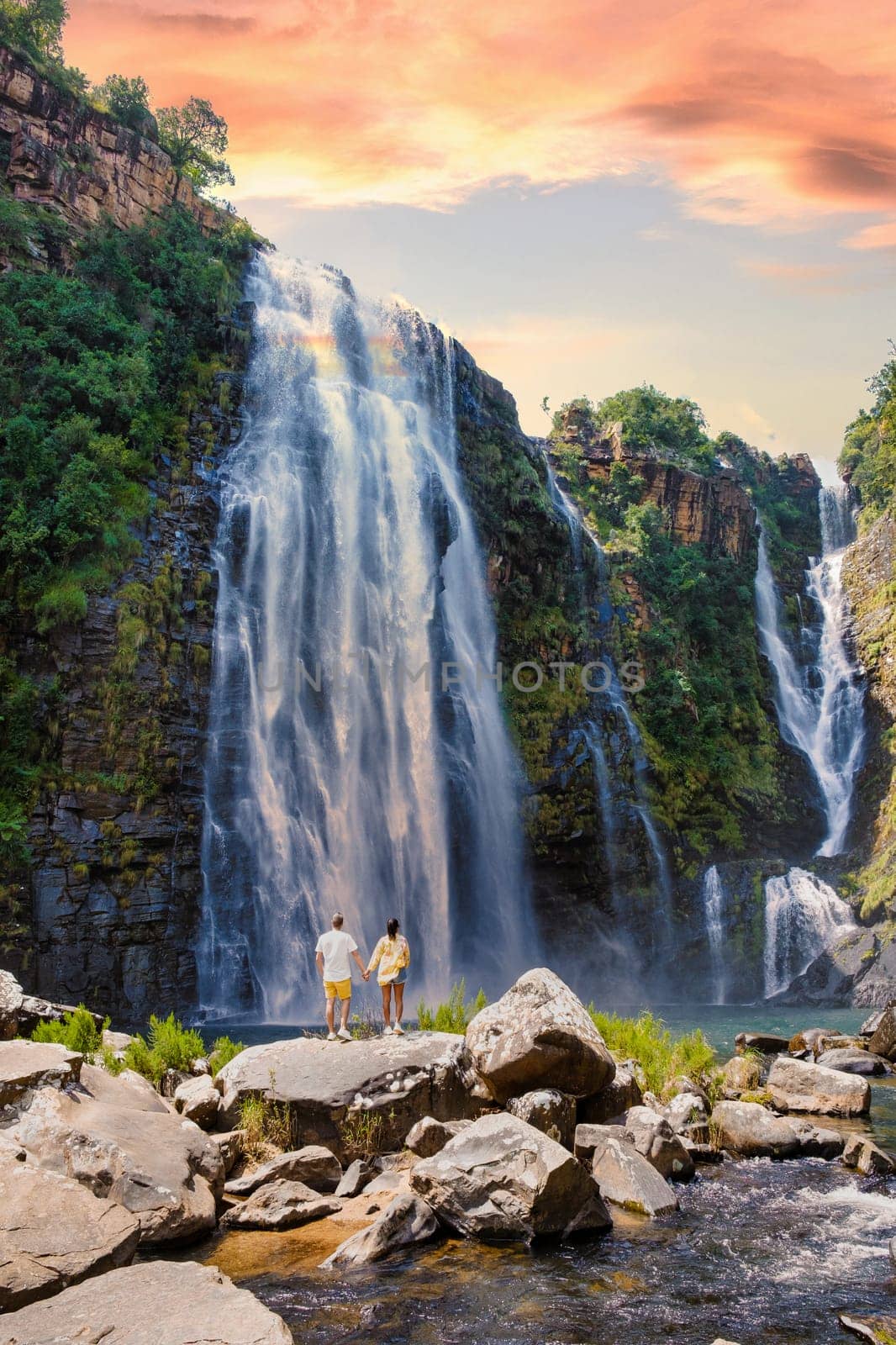Asian women and caucasian men on vacation in South Africa visit the Panorama Route South Africa, Lisbon Falls South Africa, Lisbon Falls is the highest waterfall in Mpumalanga, South Africa.