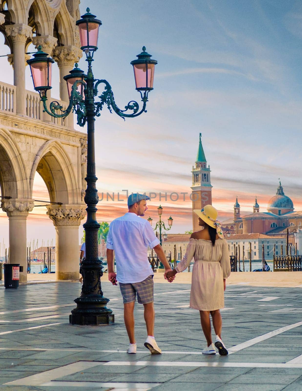 couple on a city trip in Venice, Italy view of piazza San Marco, Doge's Palace Palazzo Ducale by fokkebok