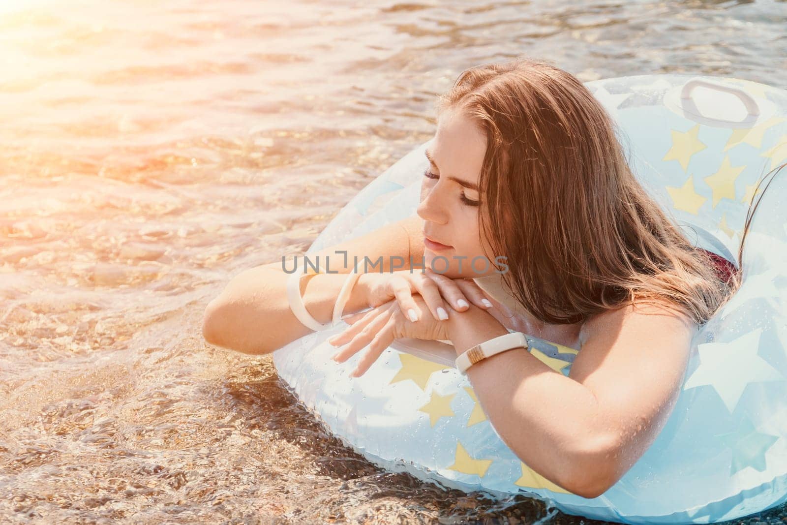 Woman summer sea. Happy woman swimming with inflatable donut on the beach in summer sunny day, surrounded by volcanic mountains. Summer vacation concept