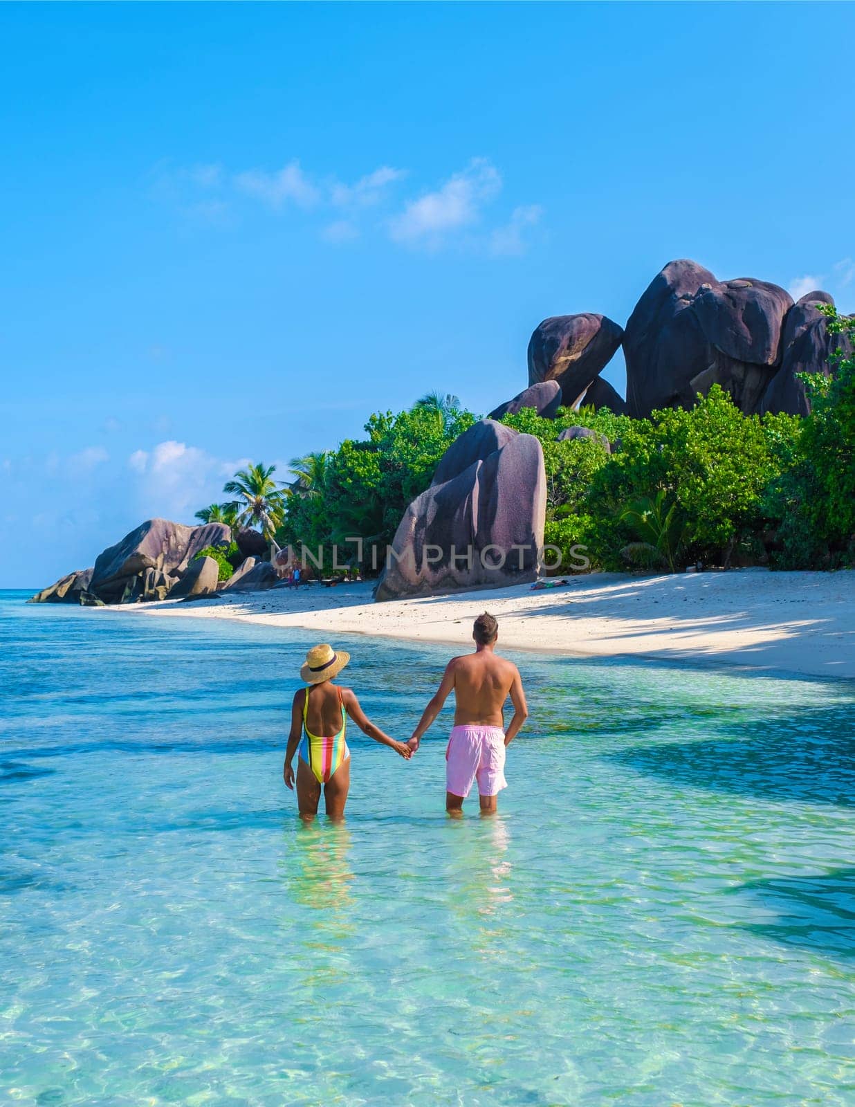 Anse Source d'Argent beach, La Digue Island, Seychelles, couple men and woman relaxing at the beach at a luxury vacation in the Seychelles
