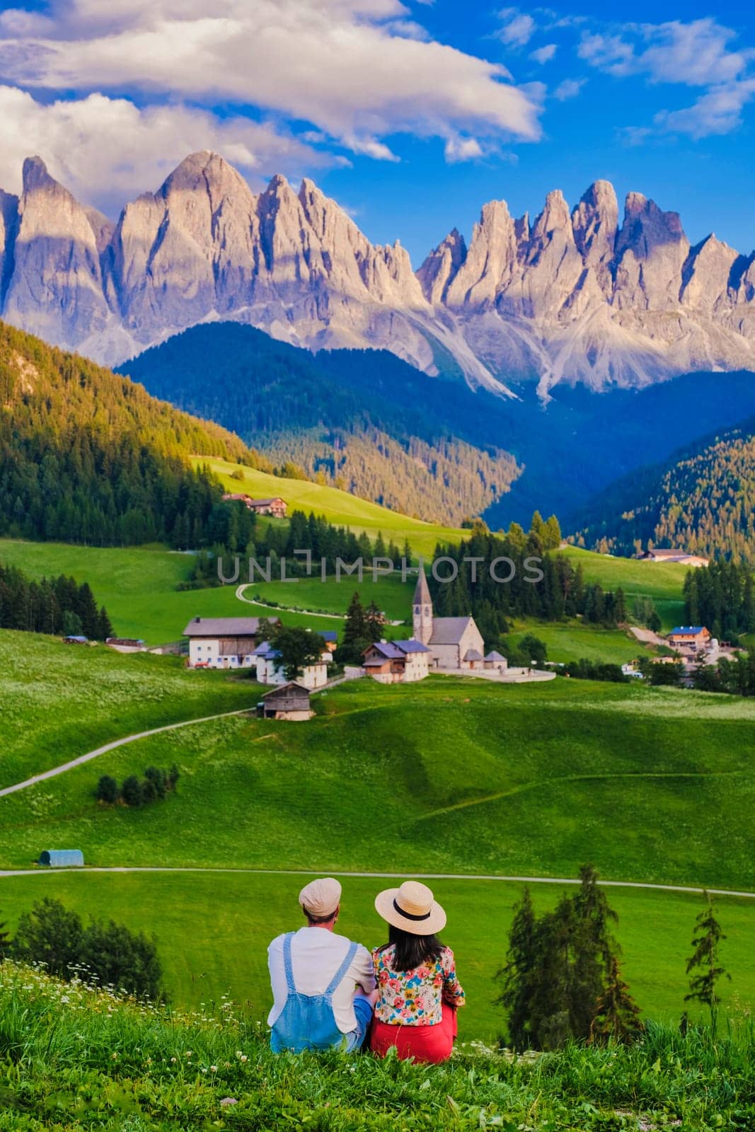 Couple viewing the landscape of Santa Maddalena Village in the Dolomites Italy, Santa Magdalena village Dolomites mountains, Val di Funes