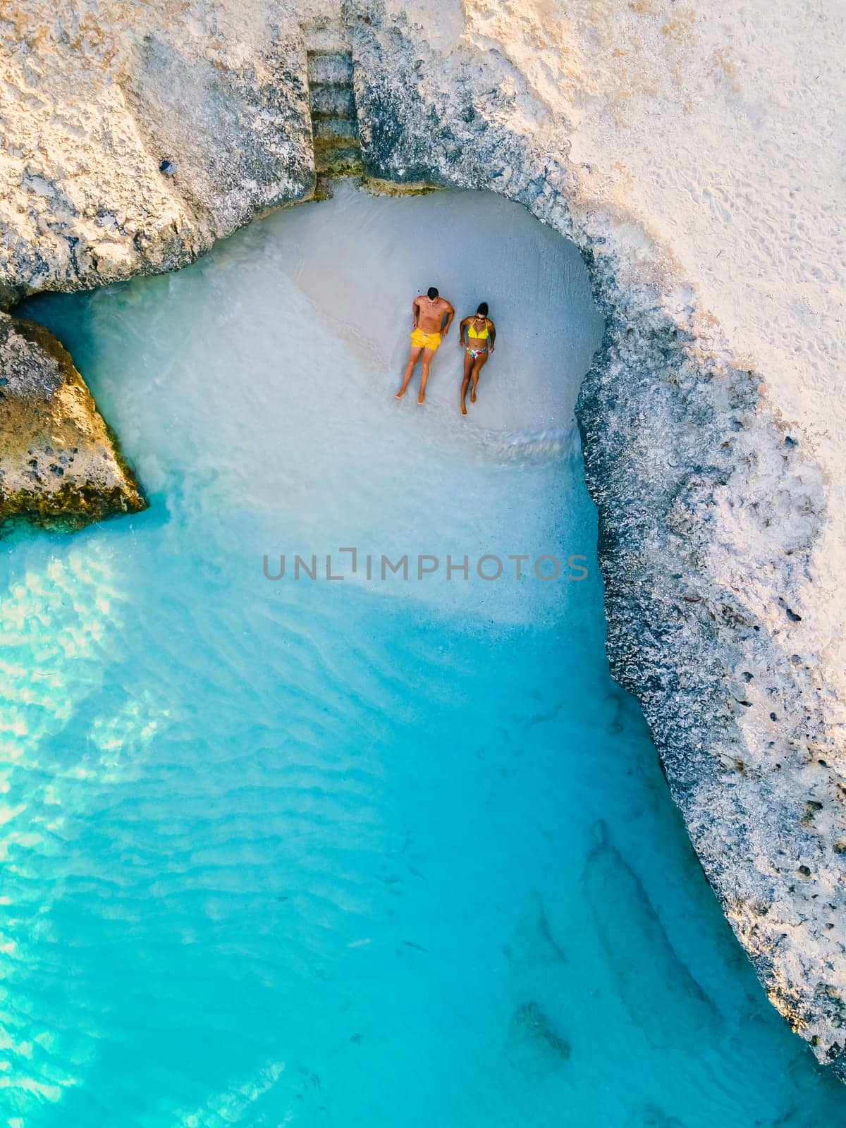 Tres Trapi Steps Triple Steps Beach Aruba. Popular beach among locals and tourists for diving and snorkeling, a couple man and woman in a crystal clear ocean in the Caribbean