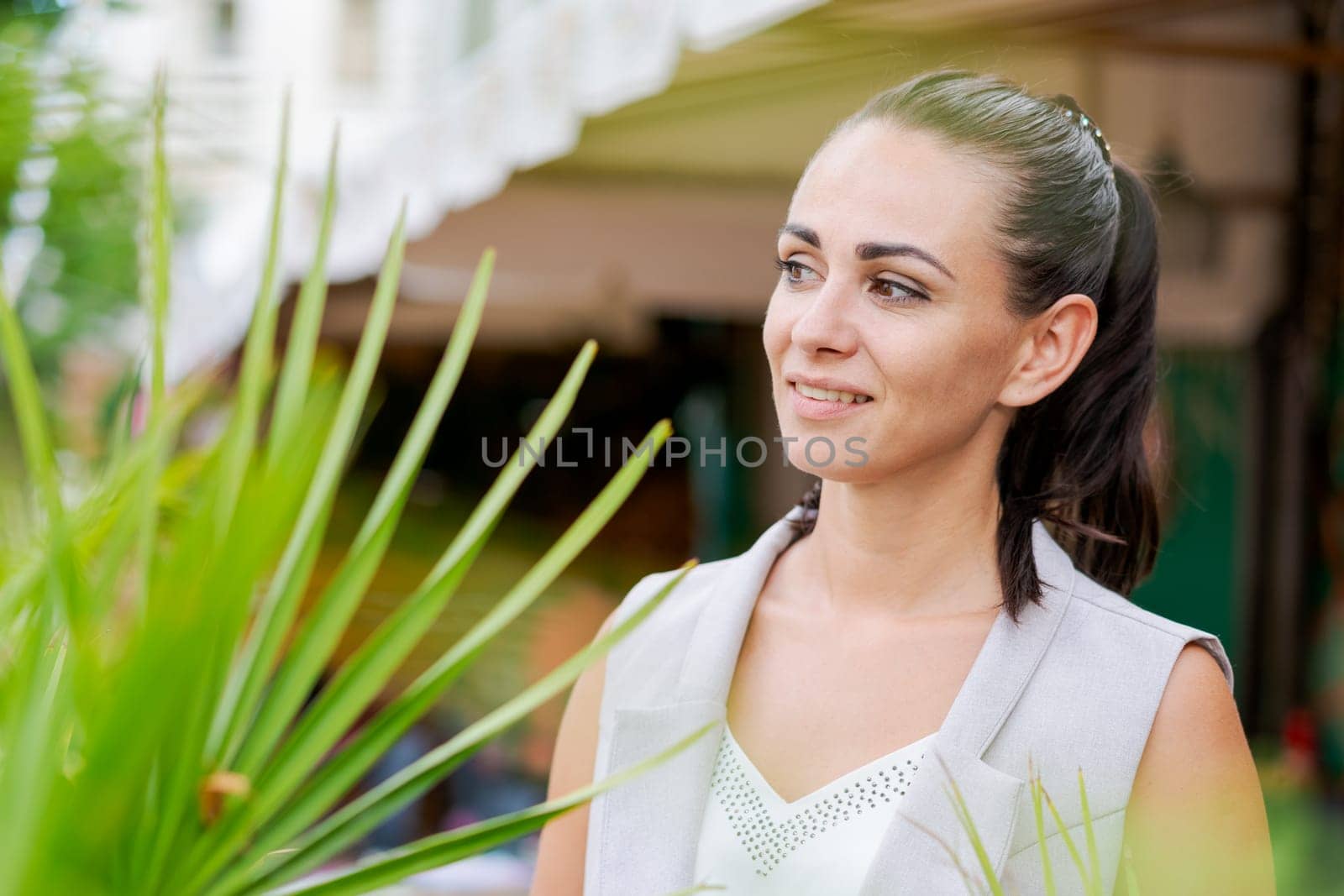 Happy businesswoman smiling while standing in suit on city street