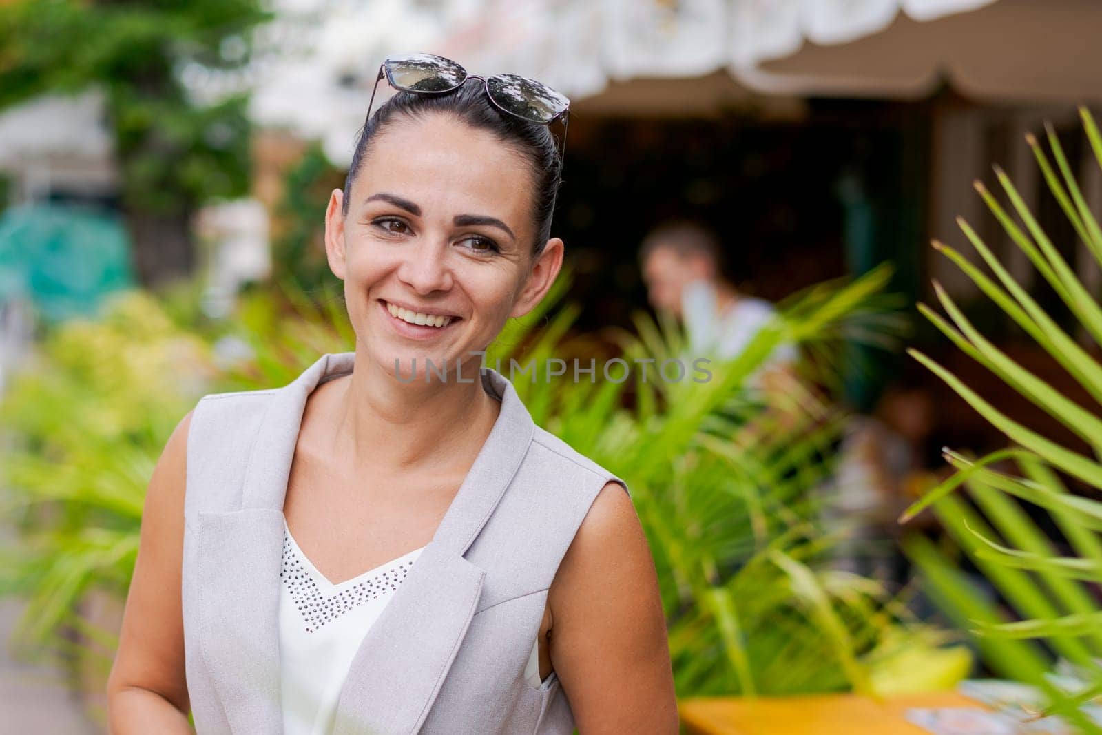 Happy businesswoman smiling while standing in suit on city street. by EkaterinaPereslavtseva