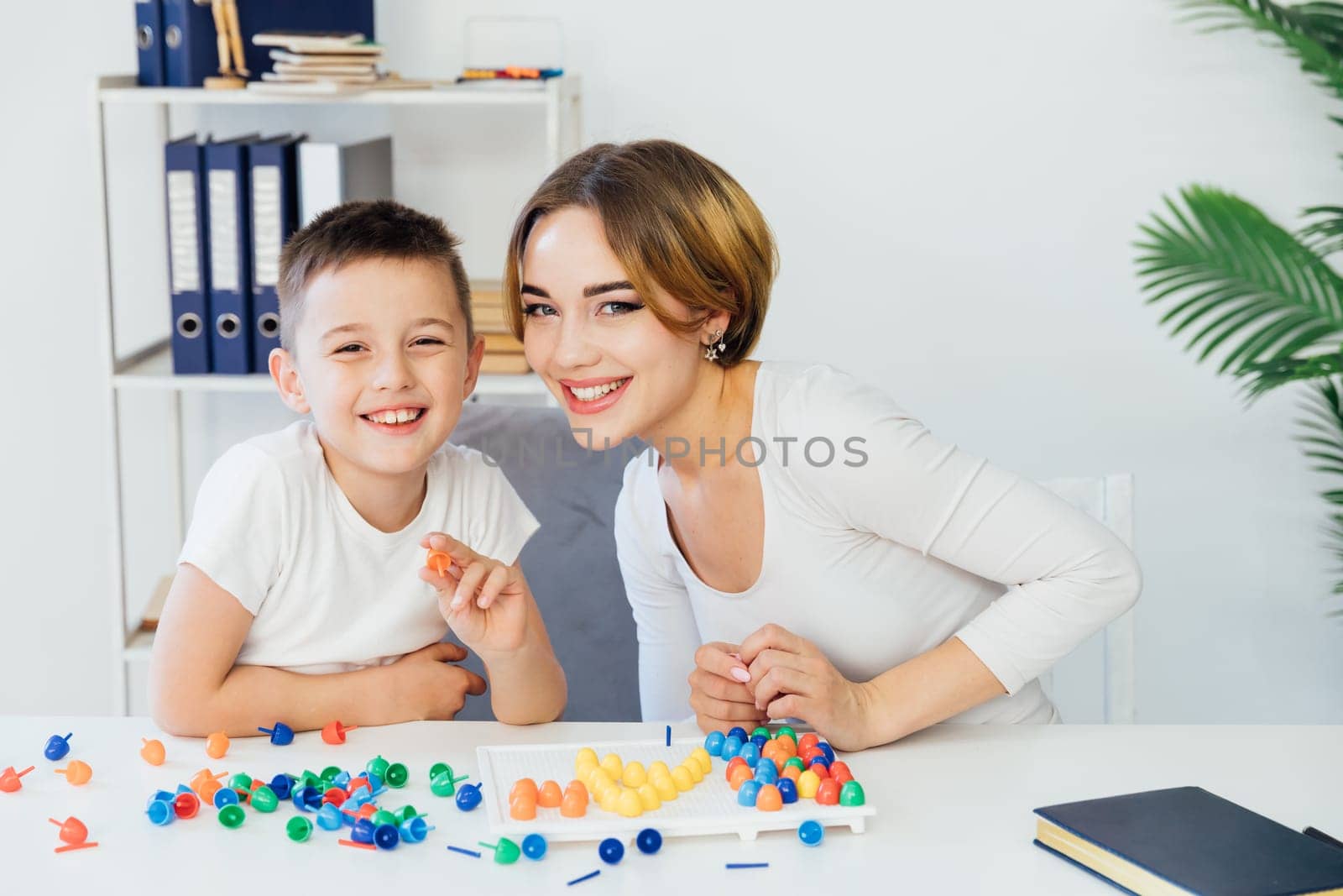 Teacher playing educational games with little boy at school