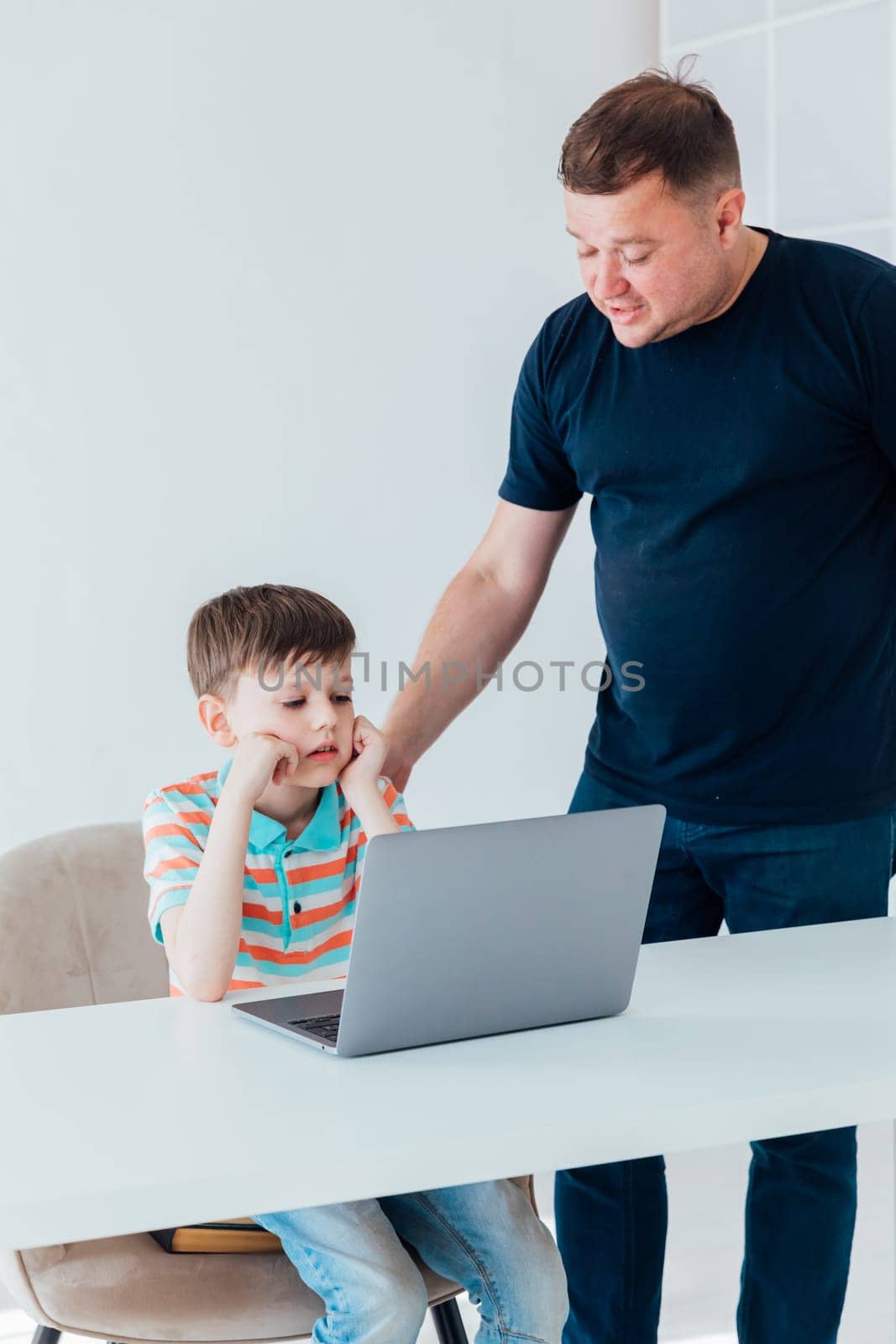 Men teaching boy on laptop in school