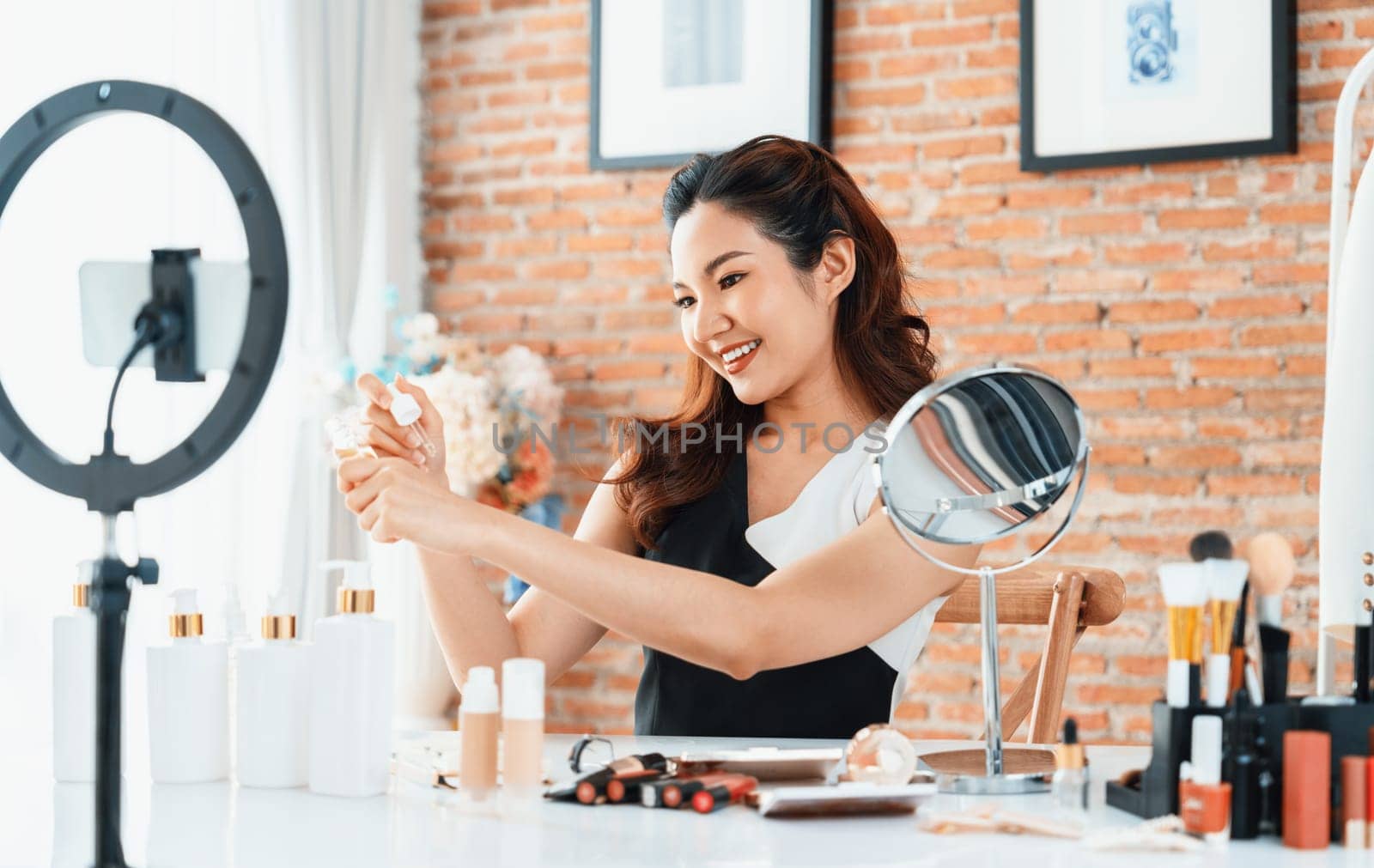 Woman influencer shoot live streaming vlog video review makeup uttermost social media or blog. Happy young girl with cosmetics studio lighting for marketing recording session broadcasting online.