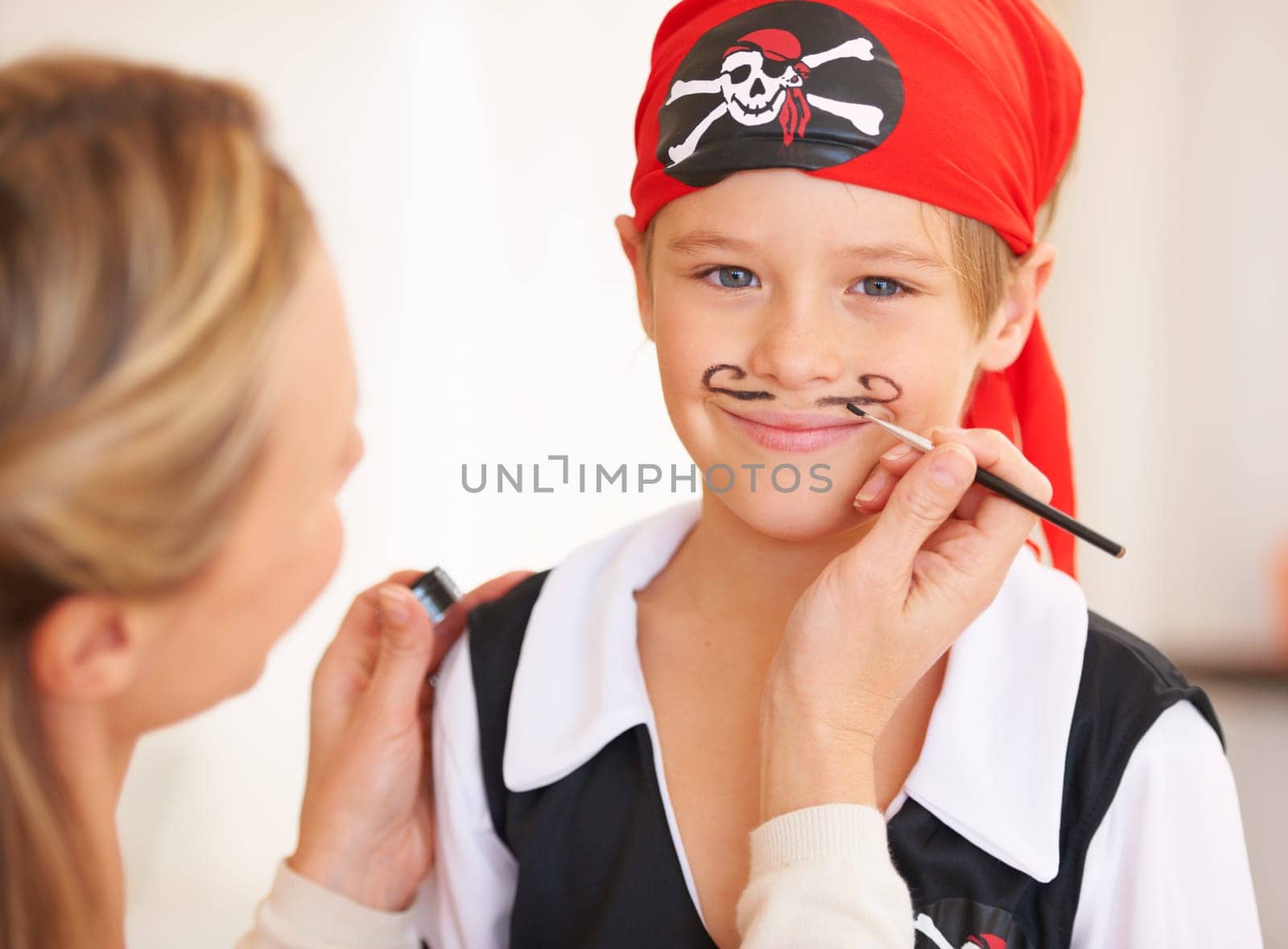 Boy, portrait or pirate face paint with woman, halloween or holiday happiness in childhood in home. Child, mother and theme make up for vacation, clothes and love care for party celebration in house.