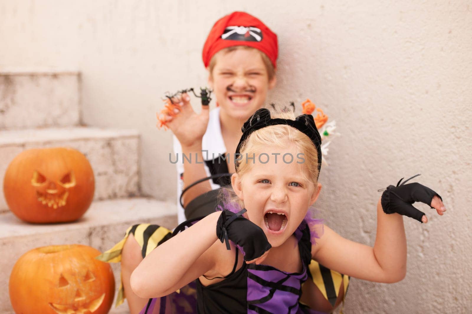 Siblings, portrait and halloween costume by outdoor, theme paint and happiness in childhood. Boy, girl or scary face for holiday party event with pumpkin, excited fairy or pirate by backyard stairs.