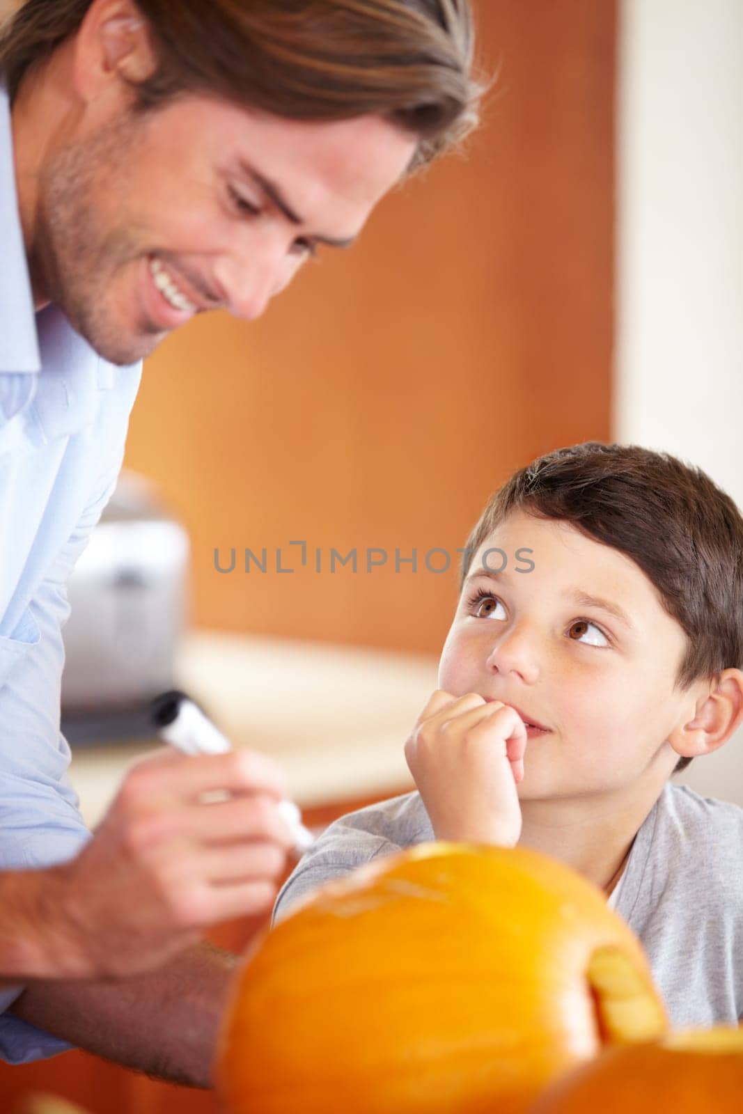 Halloween, pumpkin and father with child in the kitchen for holiday celebration at home. Creative, smile and happy dad with boy kid bonding and carving vegetable for decoration or tradition at house