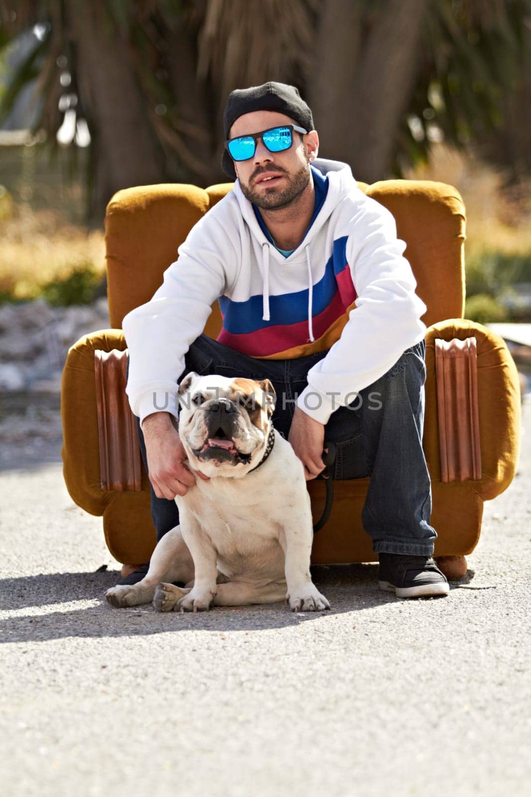 Couch, city and portrait of man with dog in street for urban fashion, casual style and trendy outfit. sunglasses, pets and person on sofa in road with canine, bulldog and best friend for relaxing by YuriArcurs