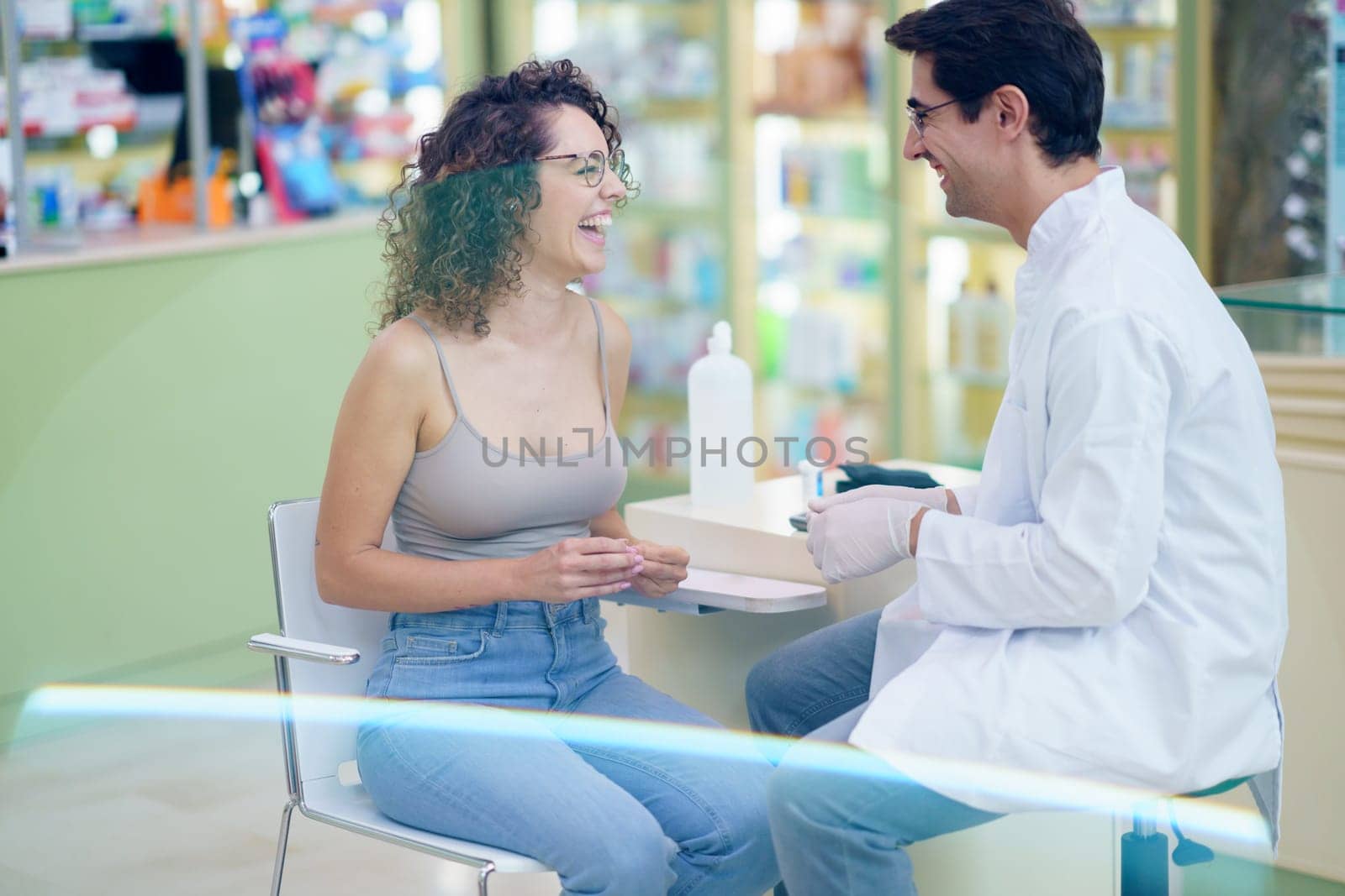 Happy pharmacist and patient during blood sugar test in pharmacy by javiindy