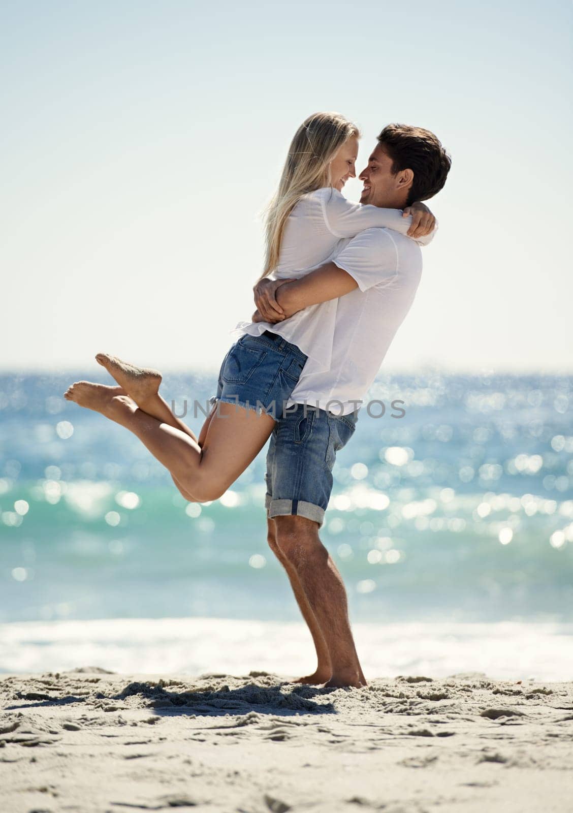 Couple, hug and fun by beach in summer with love, care and support together on a holiday. Happy, vacation and date smile by the sea in Miami with freedom and travel by the ocean on a trip outdoor.