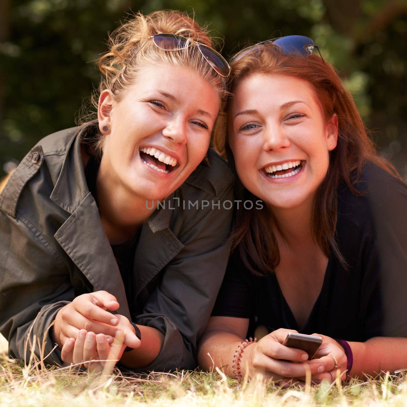Portrait, outdoor and women on the grass with smile, funny or happiness with vacation, relax or bonding together. Face, people on the ground or girls with joy, weekend break or getaway with summer.