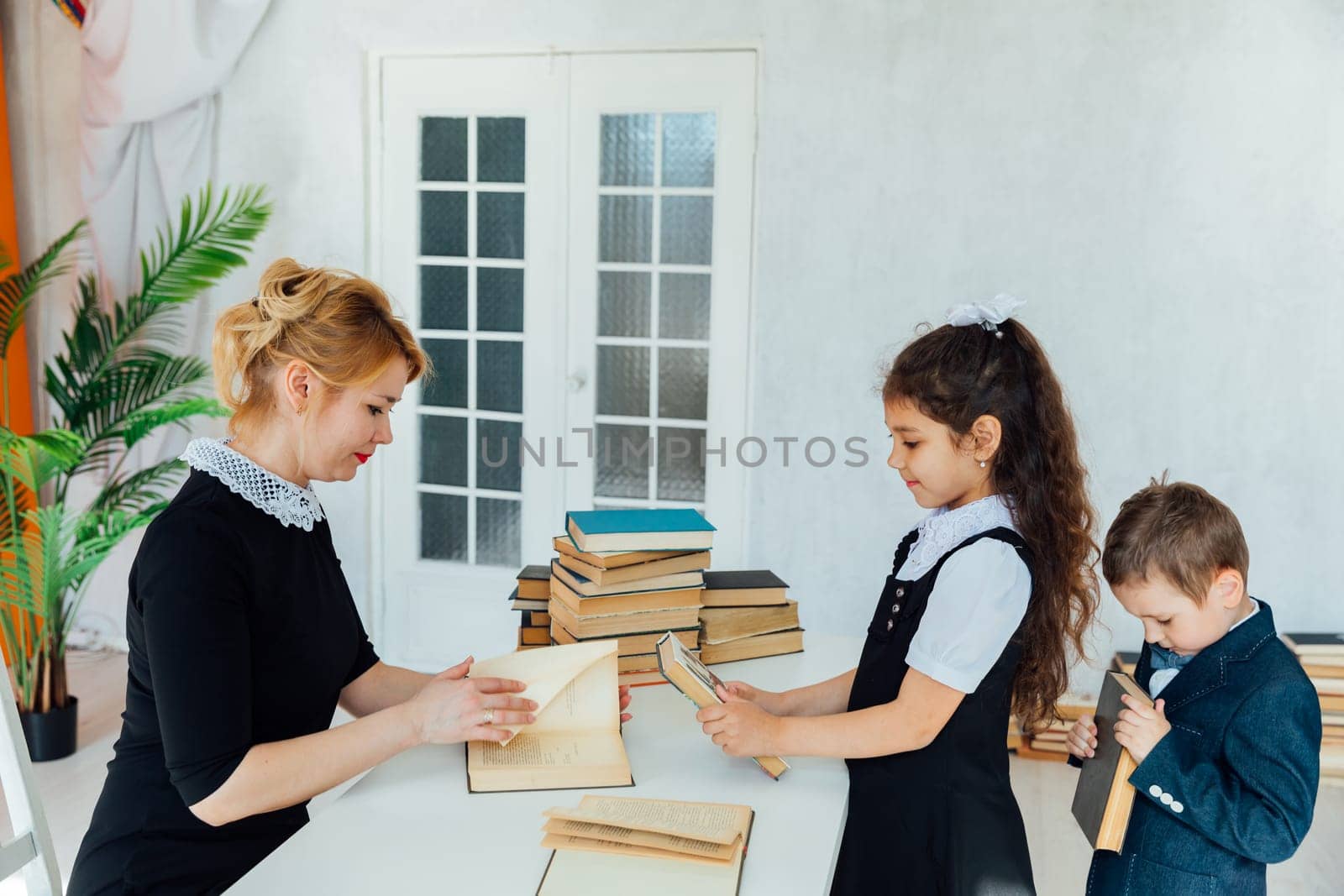 Female teacher teaching children in school classroom by Simakov