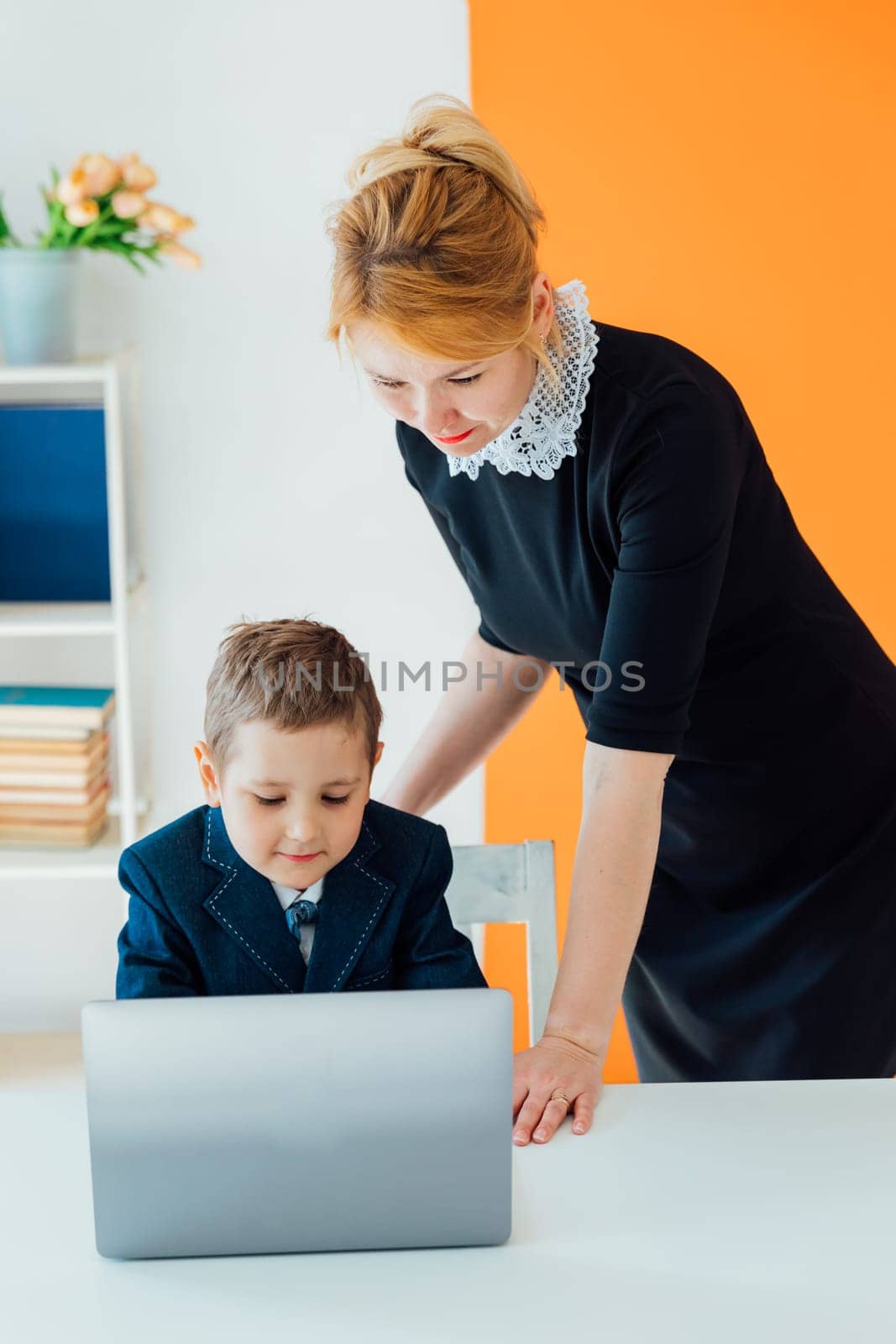 Teacher teaching schoolboy education on laptop by Simakov