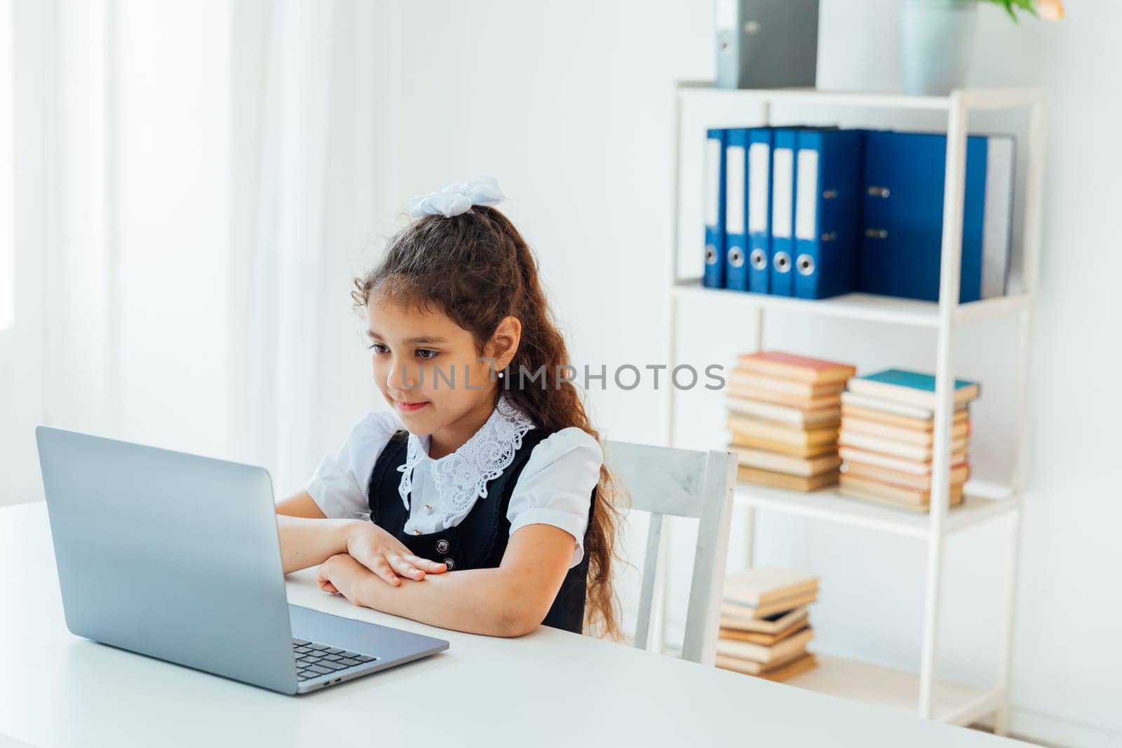 girl sitting at desk with laptop at school