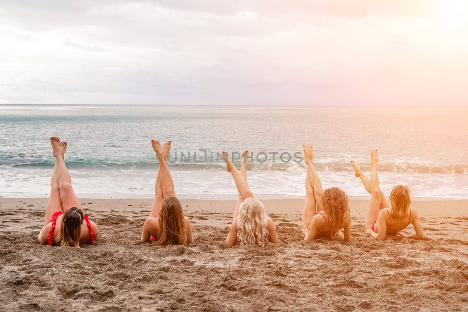 Big happy family or group of five friends is having fun against sunset beach. Beach holidays concept