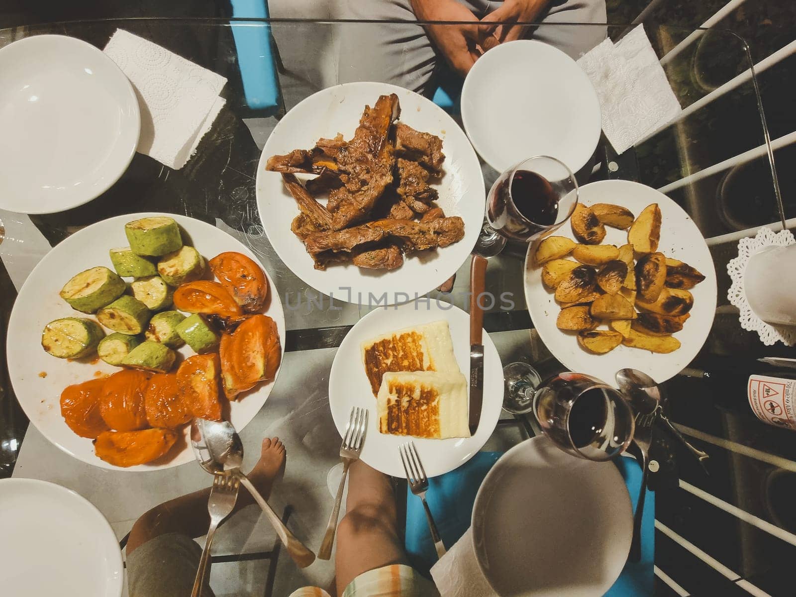 top view of the table with dinner. BBQ meat, grilled vegetables, grilled cheese, glasses of wine. flat lay. soft focus