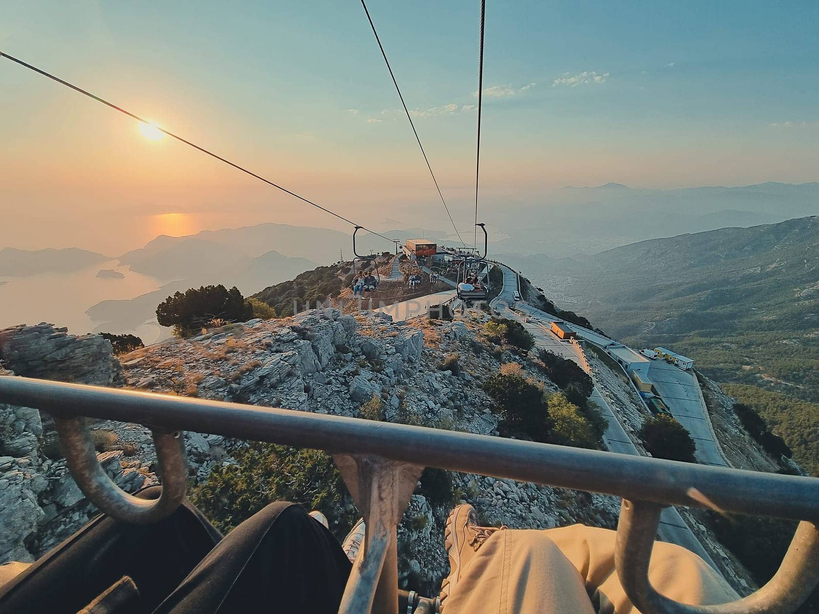 picturesque sunset in mountains on cable car. beautiful view of sea, mountains and setting sun. soft focus. concept of hiking, summer vacation by Leoschka