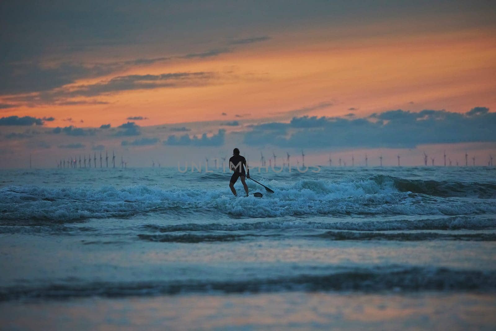 Surfer in the North Sea in the Netherlands at night by Viktor_Osypenko