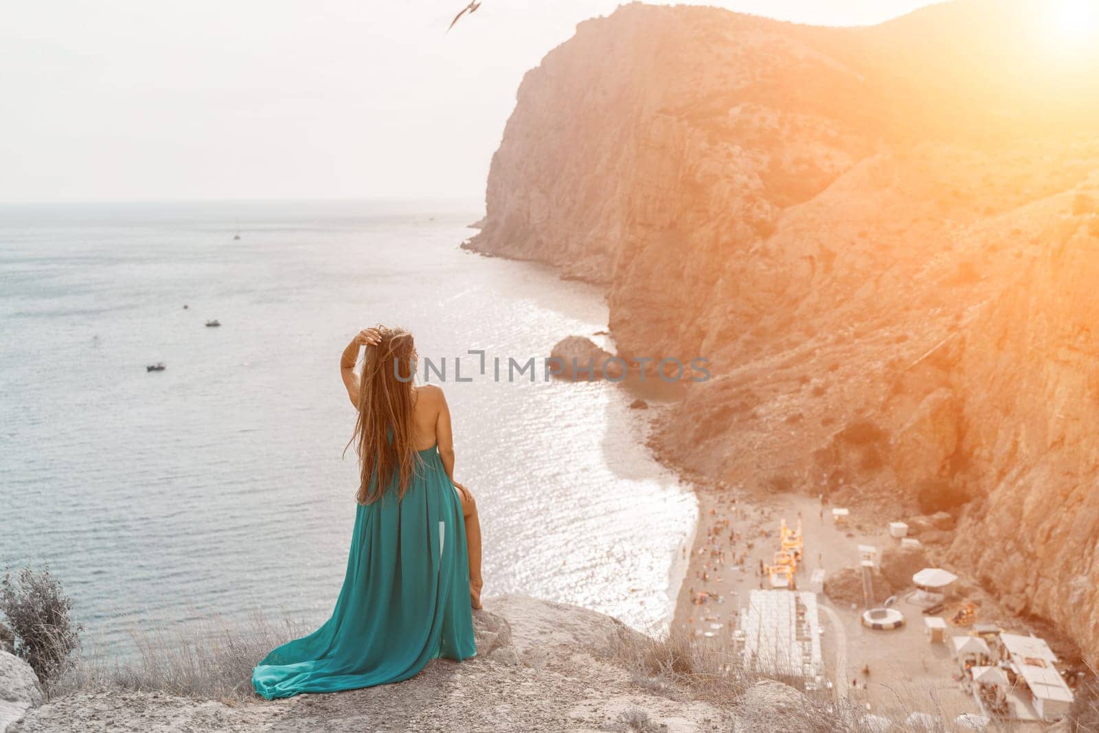 Woman sea trevel green dress. Side view a happy woman with long hair in a long mint dress posing on a beach with calm sea bokeh lights on sunny day. Girl on the nature on blue sky background. by Matiunina