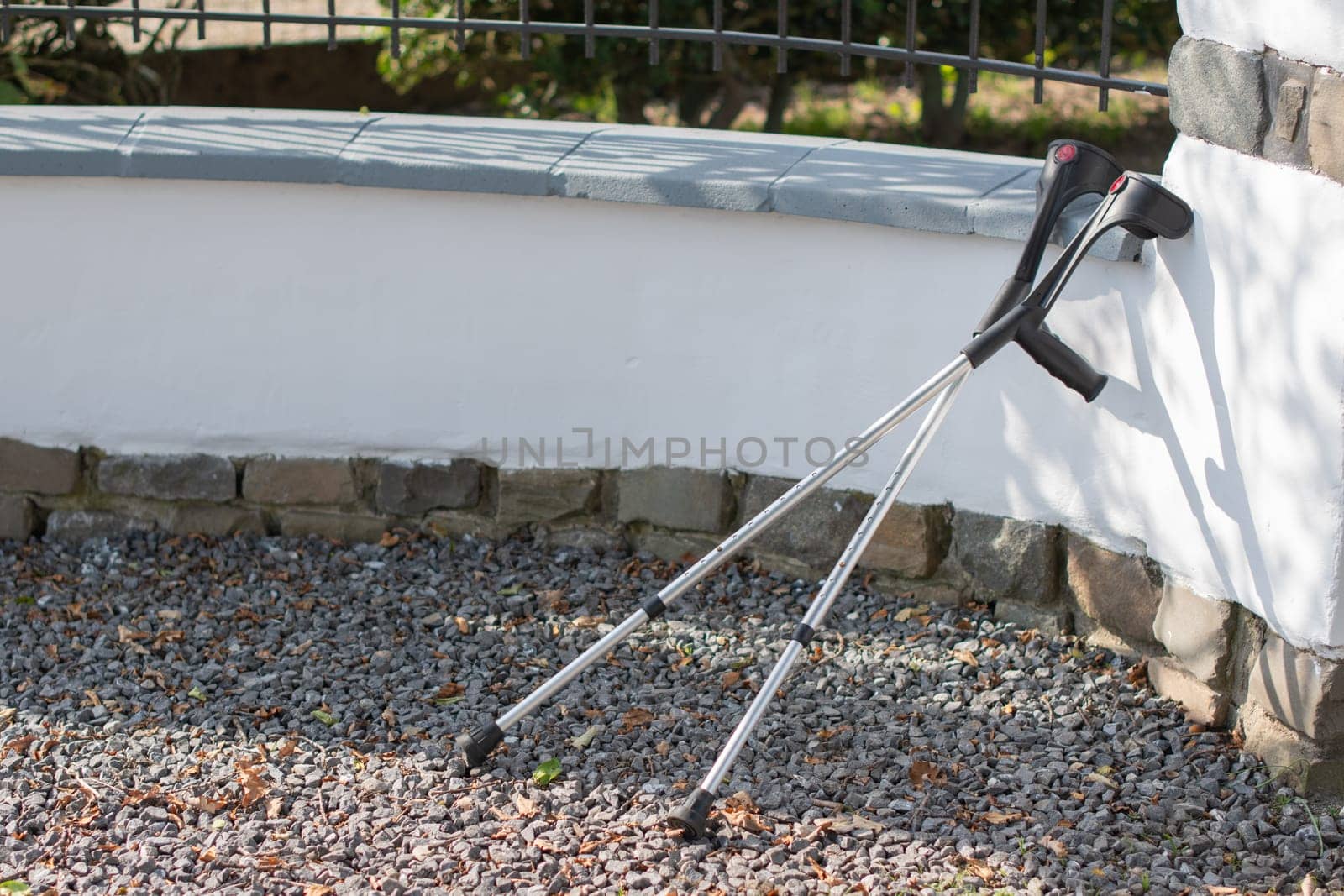 Abandoned crutches leaning against a fence are no longer needed by their owner, concept of recovery and restoration of walking, high quality photo