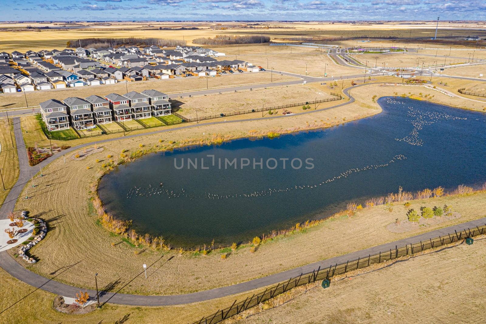 Discover Kensington in Saskatoon from a bird's-eye view. This drone image highlights the neighborhood's modern architecture, green spaces, and the lively, community-focused atmosphere.