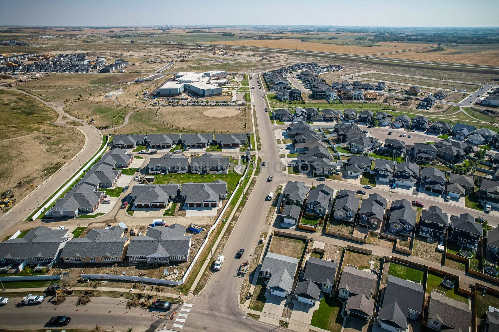 Elevated view of Rosewood neighborhood in Saskatoon, presenting a tapestry of urban design intertwined with Saskatchewan's serene natural canvas.