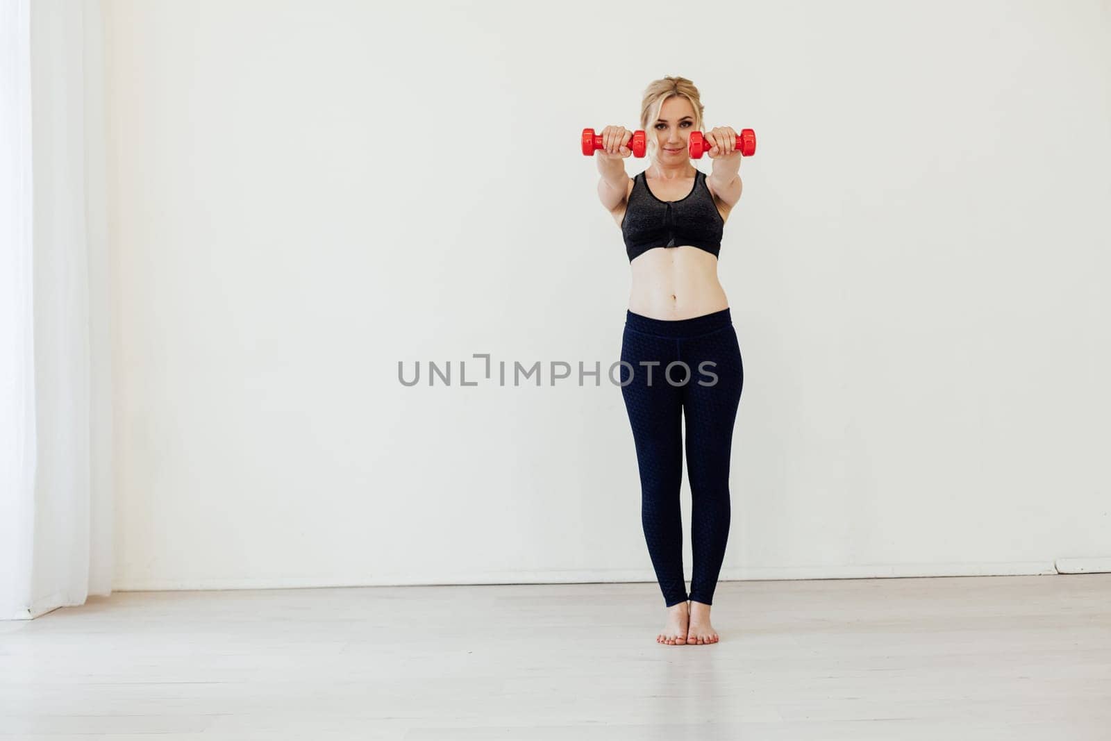 Female athlete engaged in fitness with dumbbells sport by Simakov