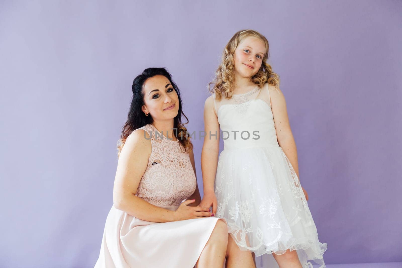 Mom and daughter in dresses hold hands