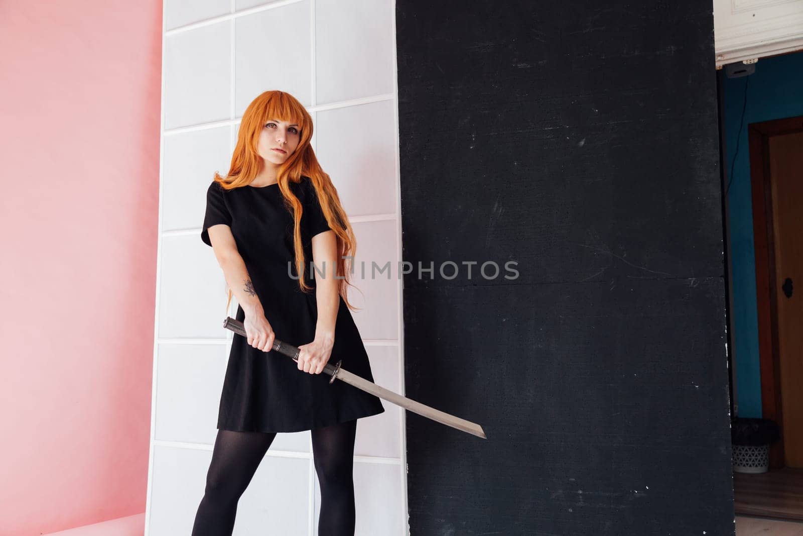 Woman cosplayer with red hair holds Japanese sword by Simakov