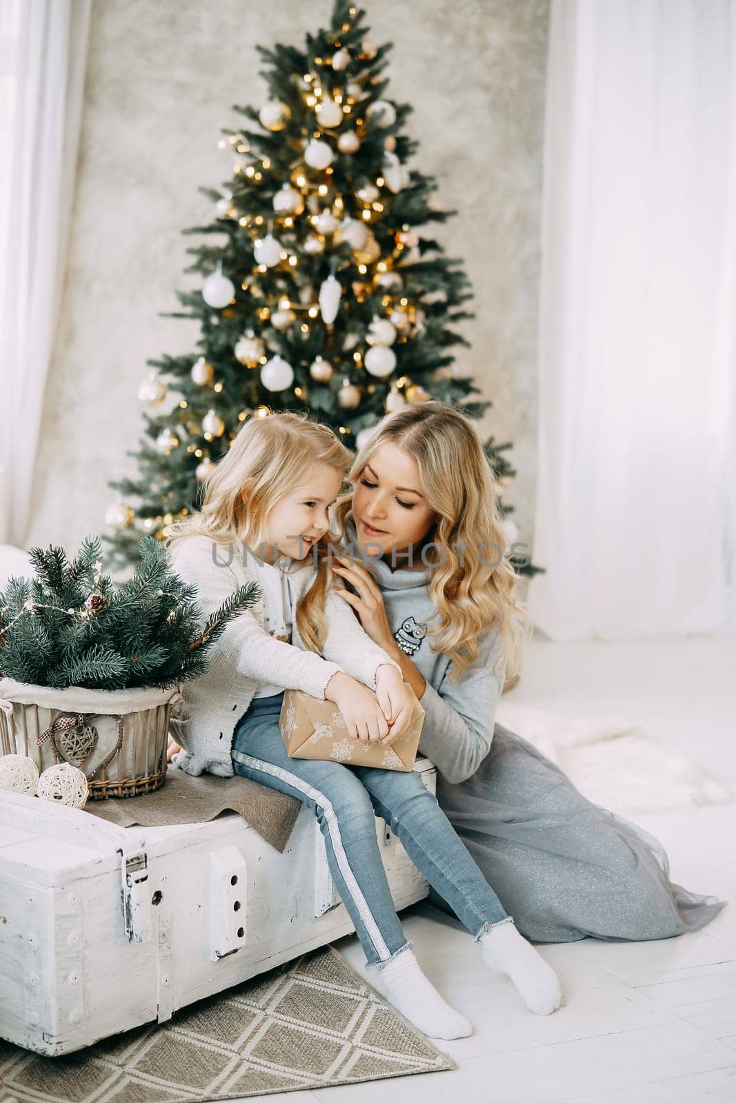Happy family: mother and daughter. Family in a bright New Year's interior with a Christmas tree