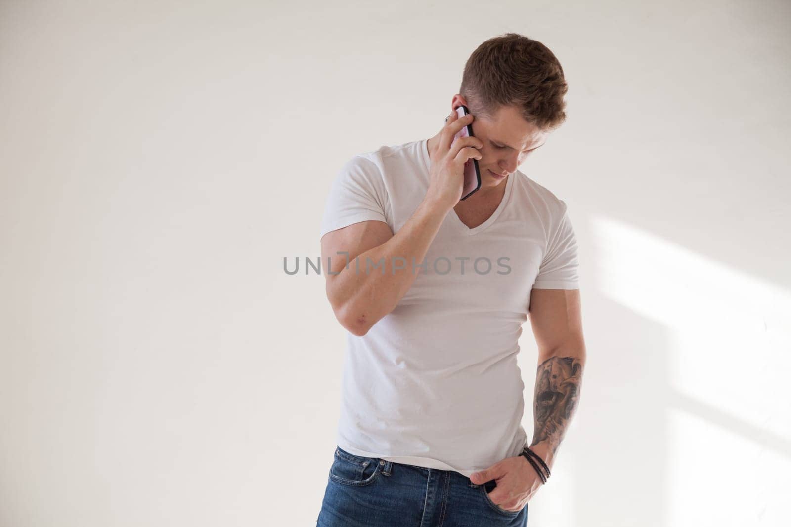 fashionable handsome man talking on a smartphone by Simakov