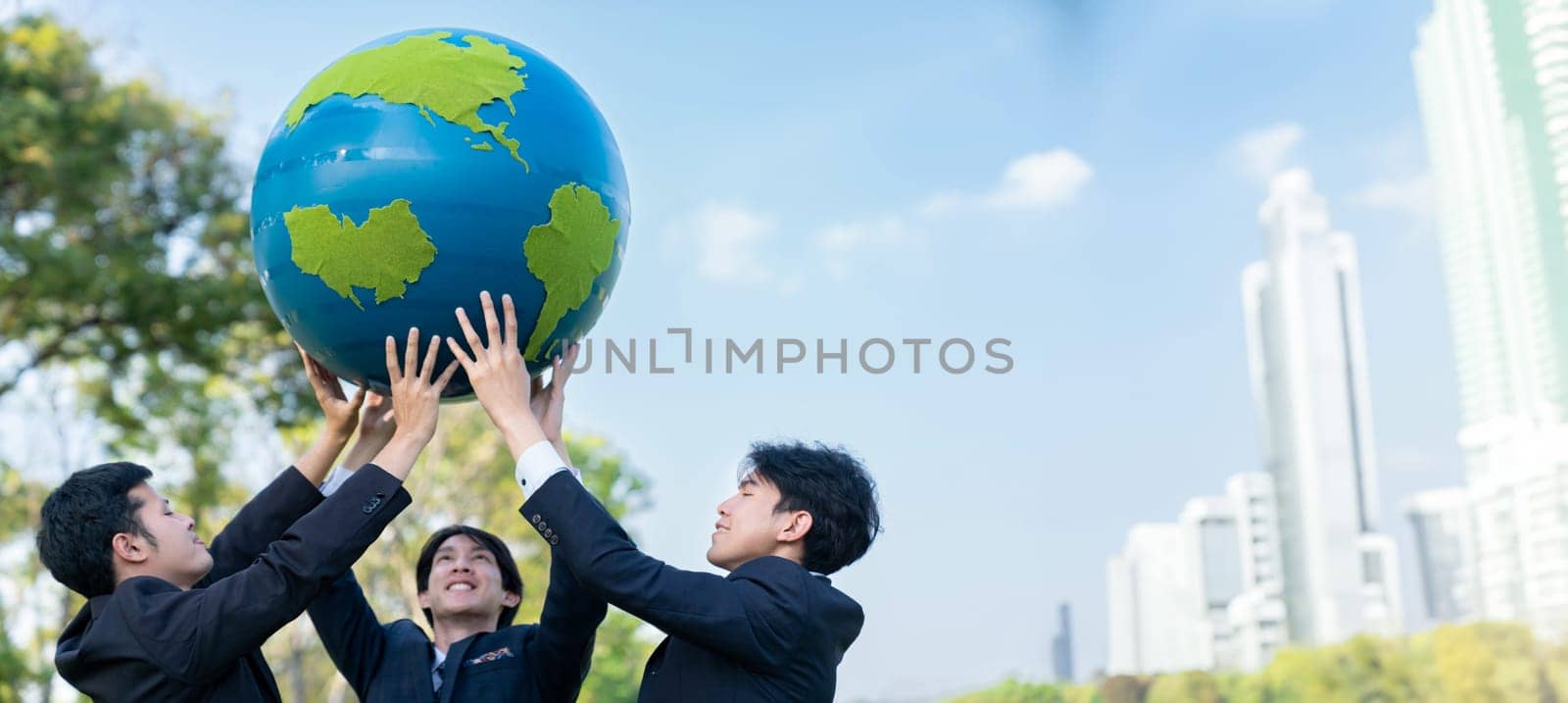 Earth day concept with big Earth globe held by group of asian business people team promoting environmental awareness with environmentally sustainability and ESG principle for brighter future. Gyre