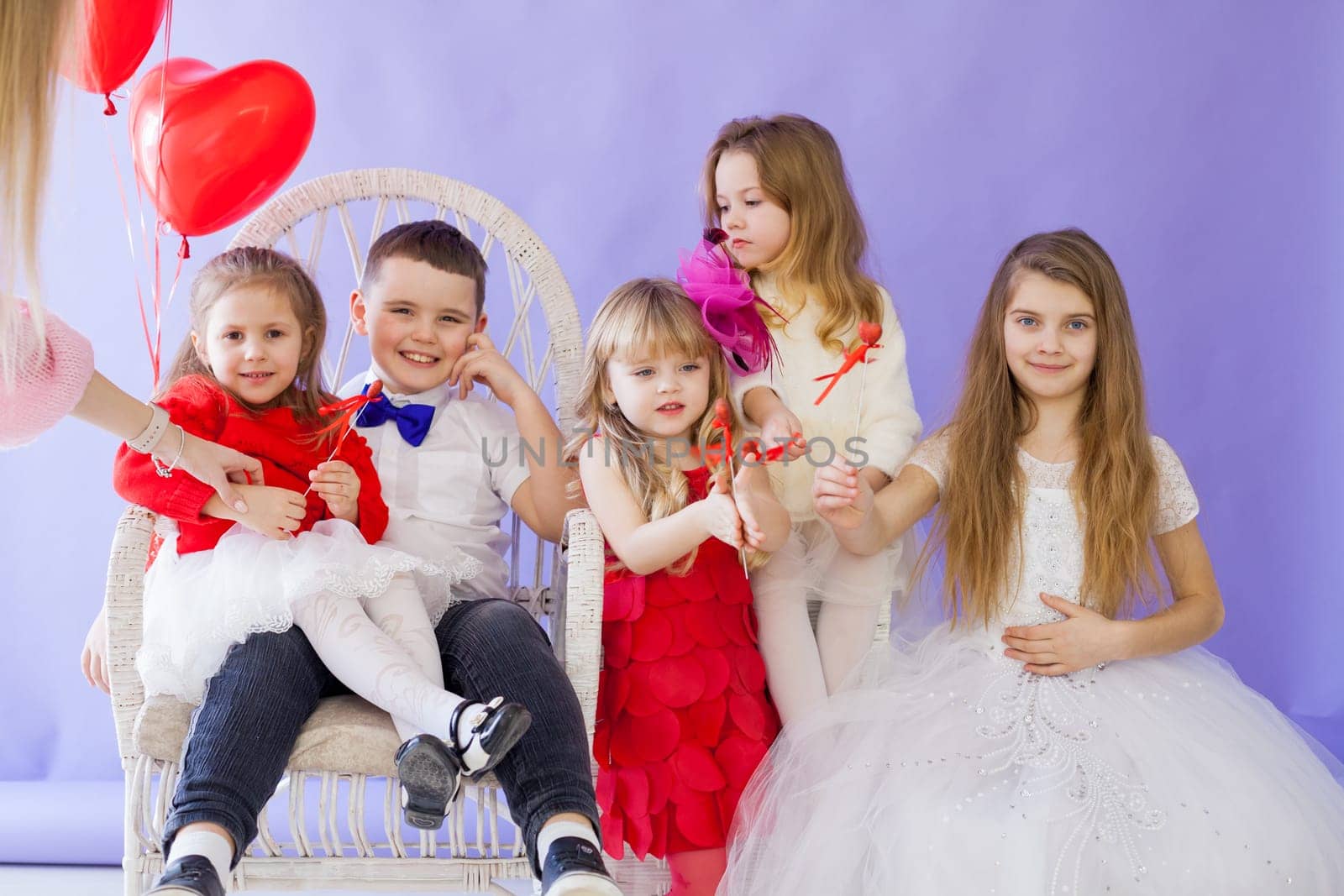 Girl's friends and boy sit with balloons by Simakov