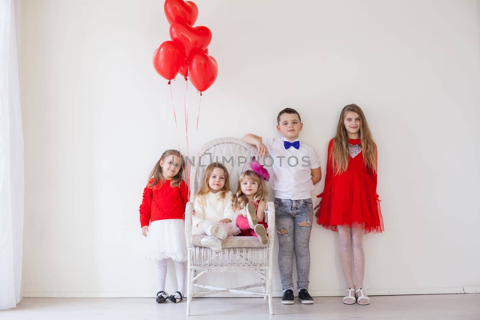 four girls and a boy in a white room with red balloons by Simakov