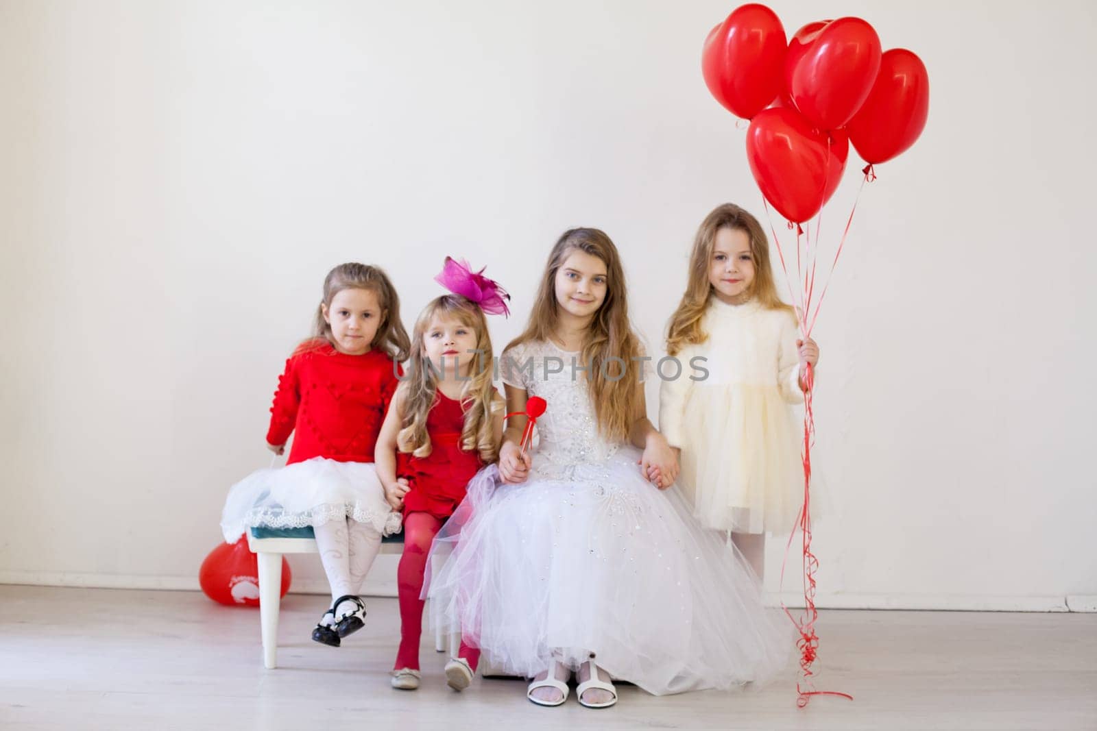 four girls in a white room with red balloons by Simakov